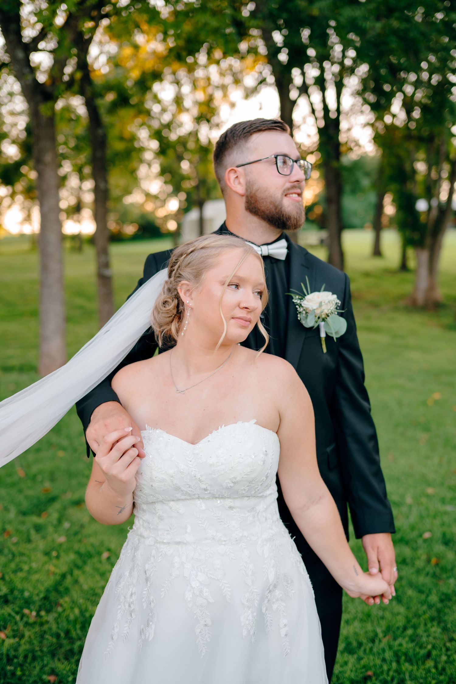 Wedding portraits in a park with natural sunlight filtering through trees.