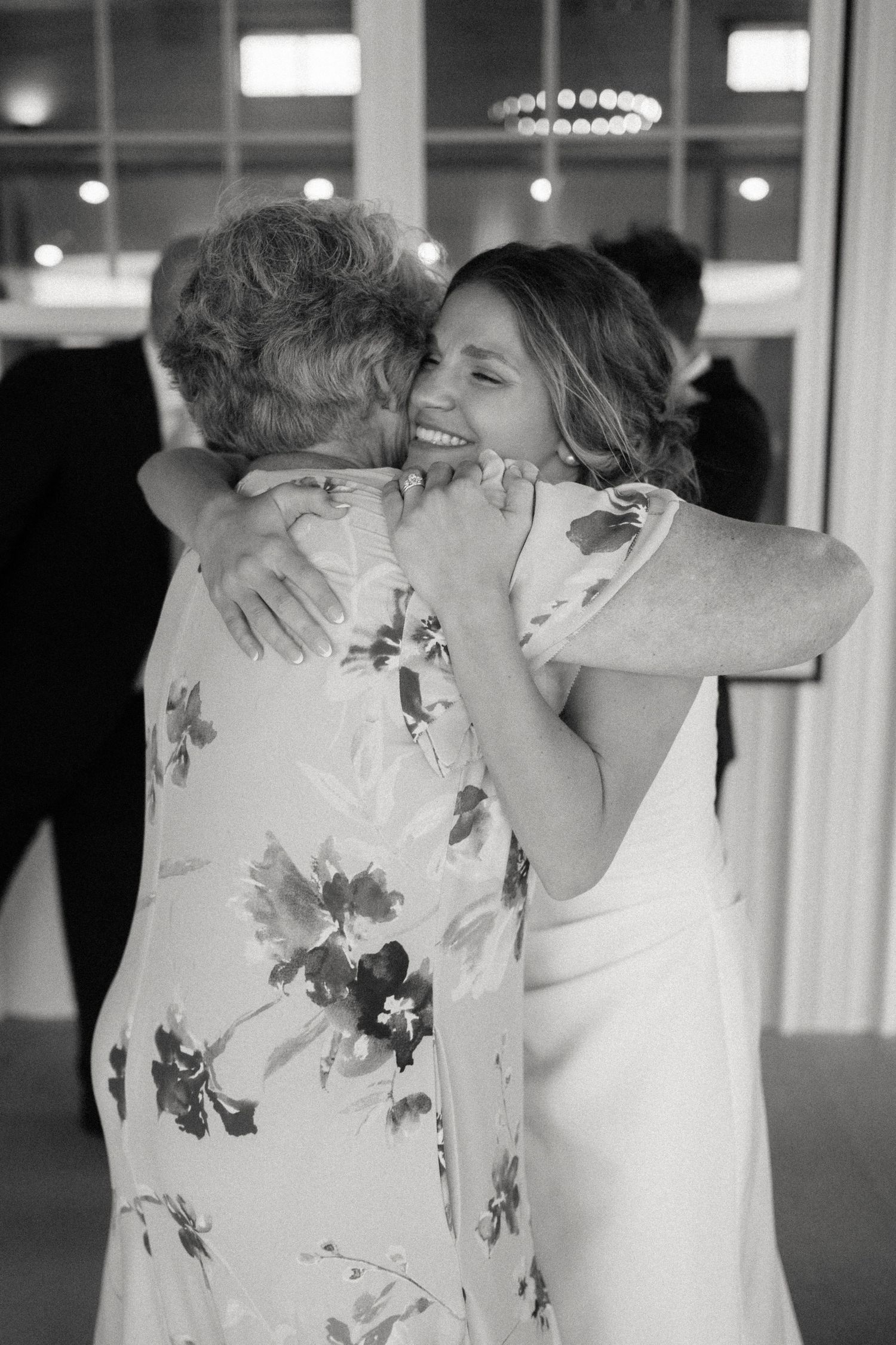 Emotional black and white wedding moment captured during indoor reception.