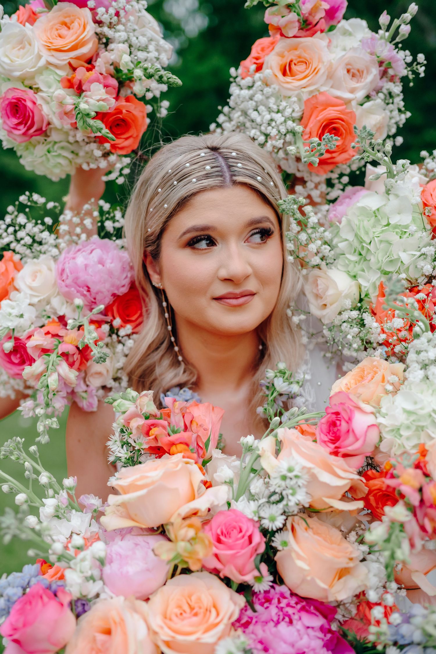 Romantic floral arrangement with coral roses and baby's breath creating a dreamy frame.