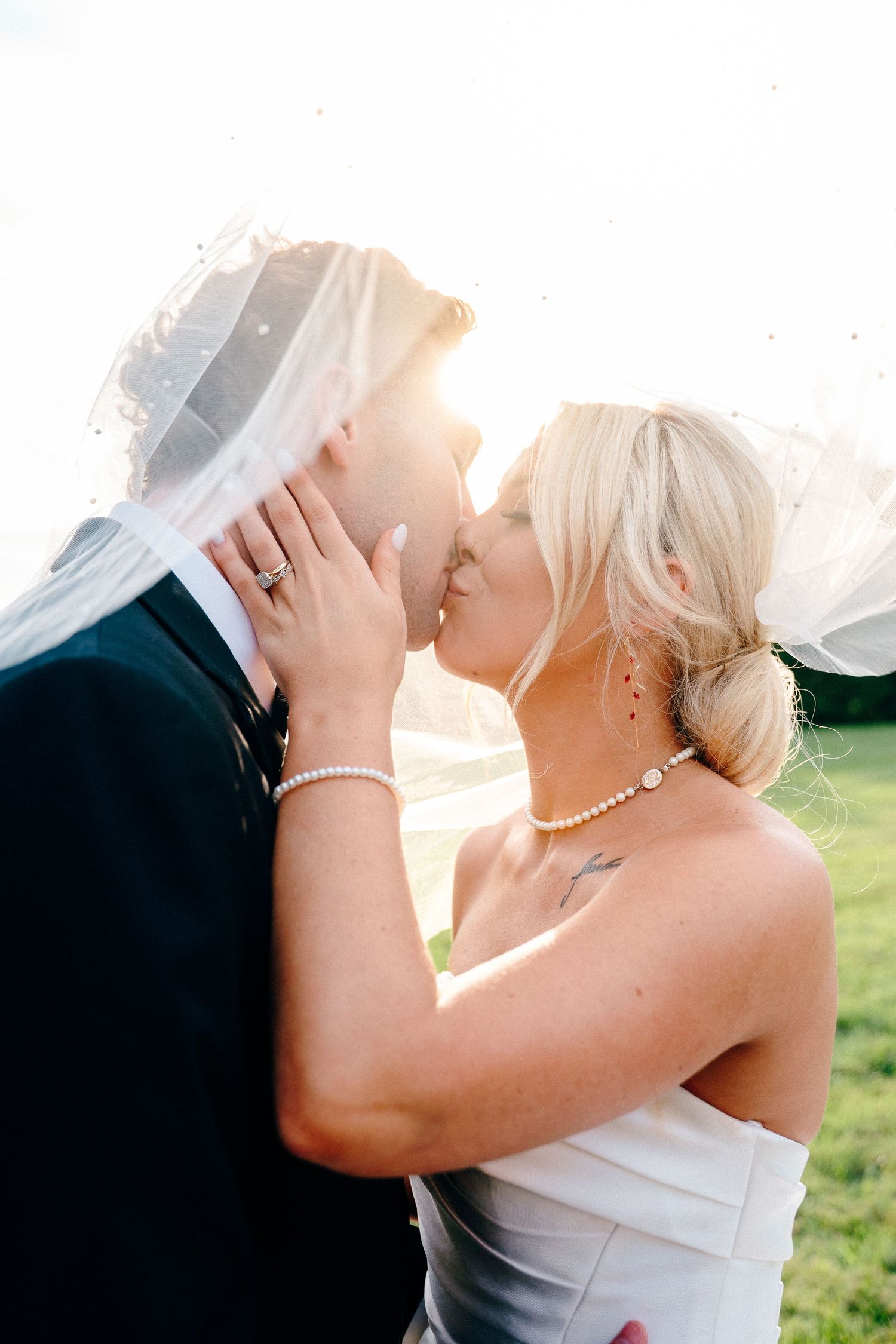 Romantic sunset wedding portrait with bride and groom embracing.