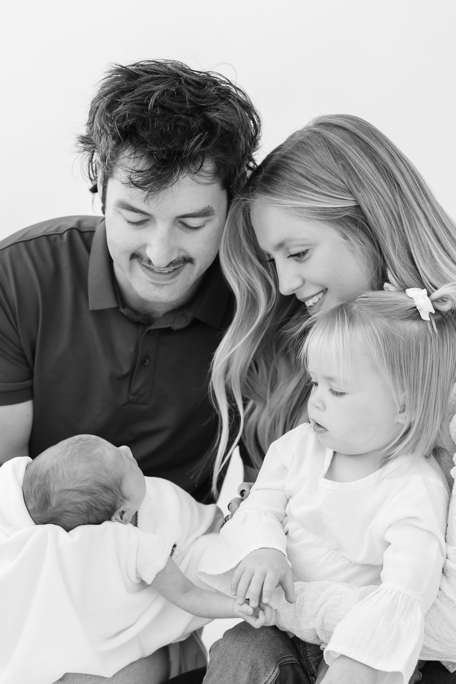 A tender black and white photo series showing a family embracing and sharing sweet moments together.