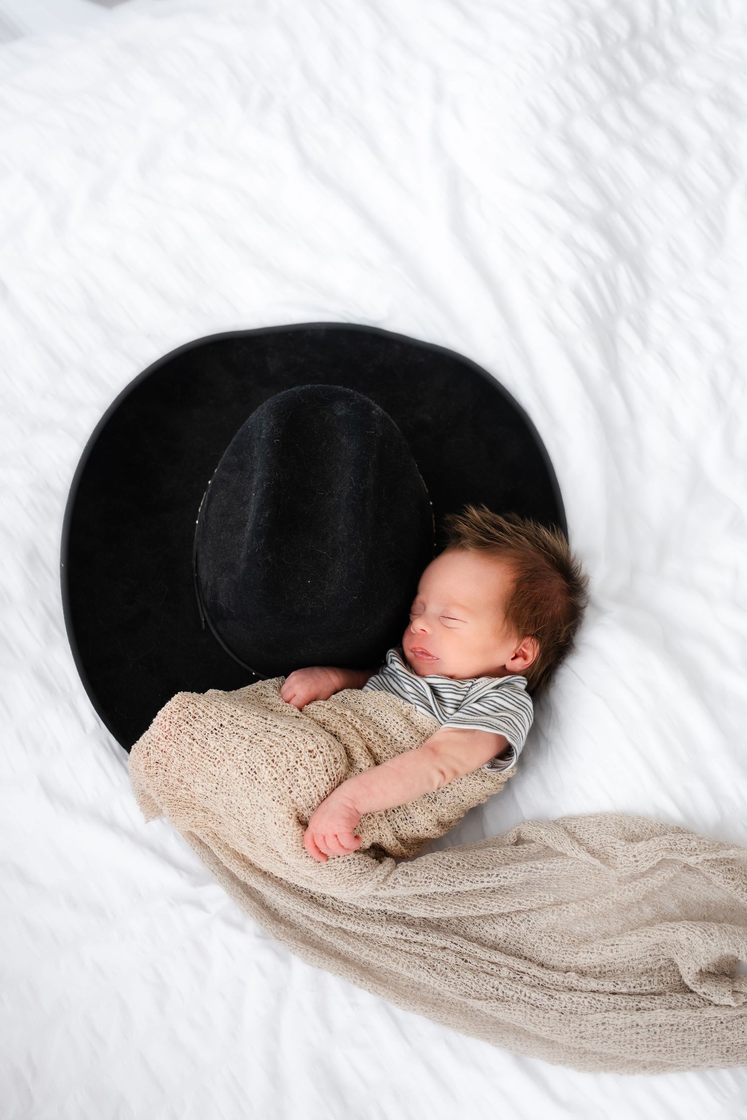 Sleeping newborn baby wrapped in beige blanket shown in sequence of four connected photos against white background.