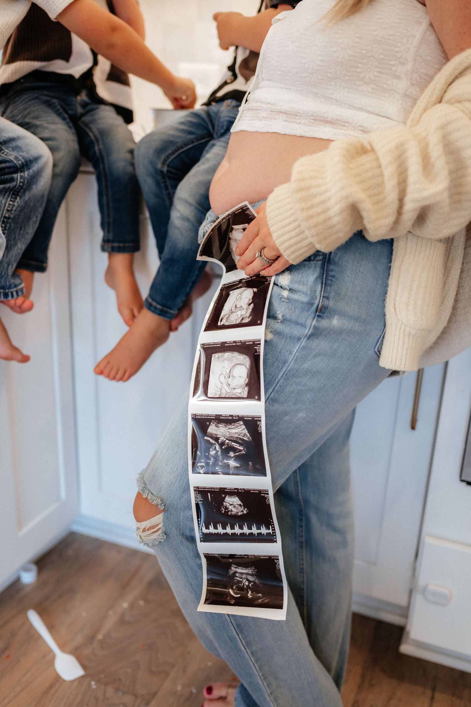 A series of photos showing ultrasound images being held while sitting on a kitchen counter.