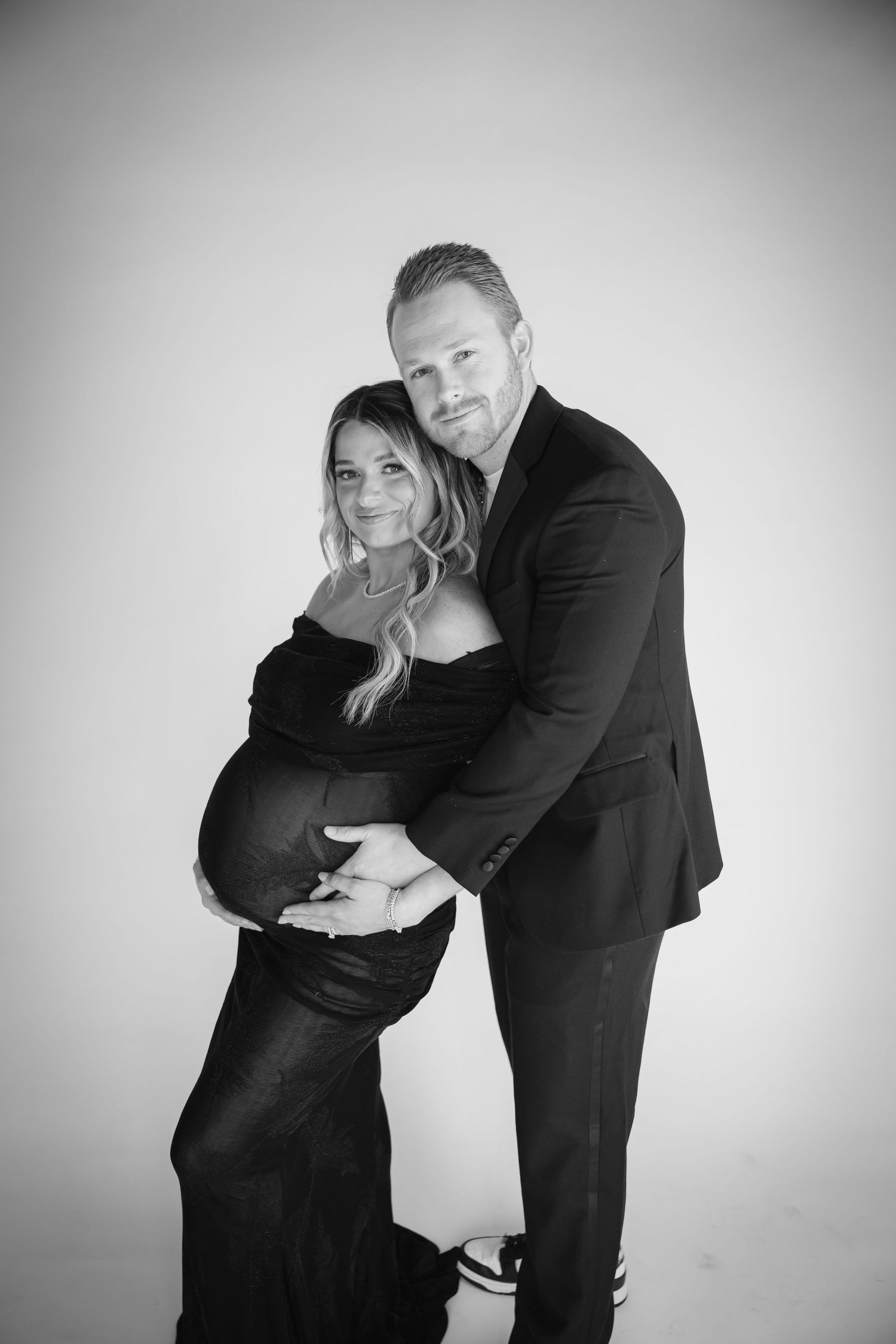 Intimate black and white maternity photos showing a couple embracing.