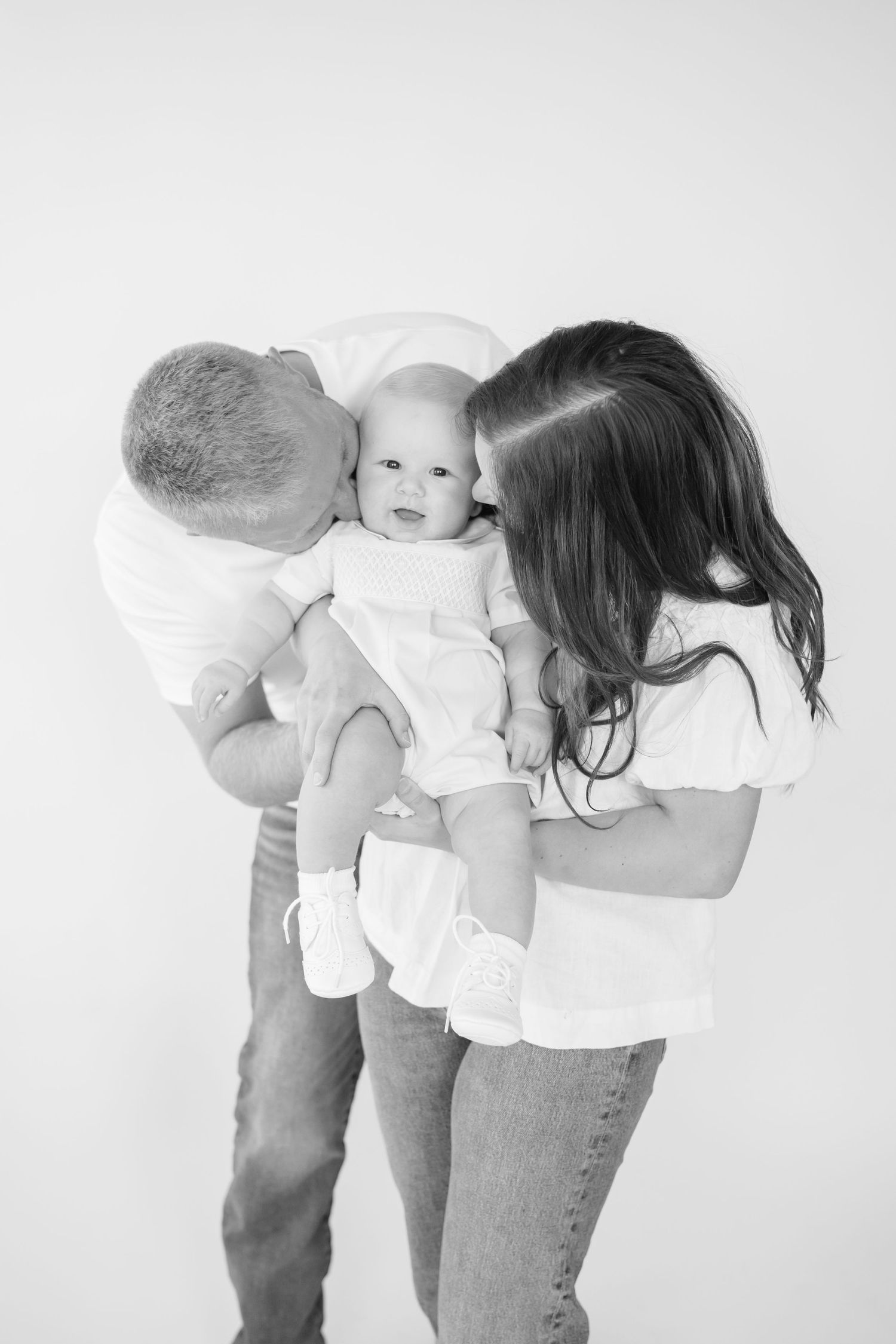 Black and white series showing playful interaction between parent and baby.