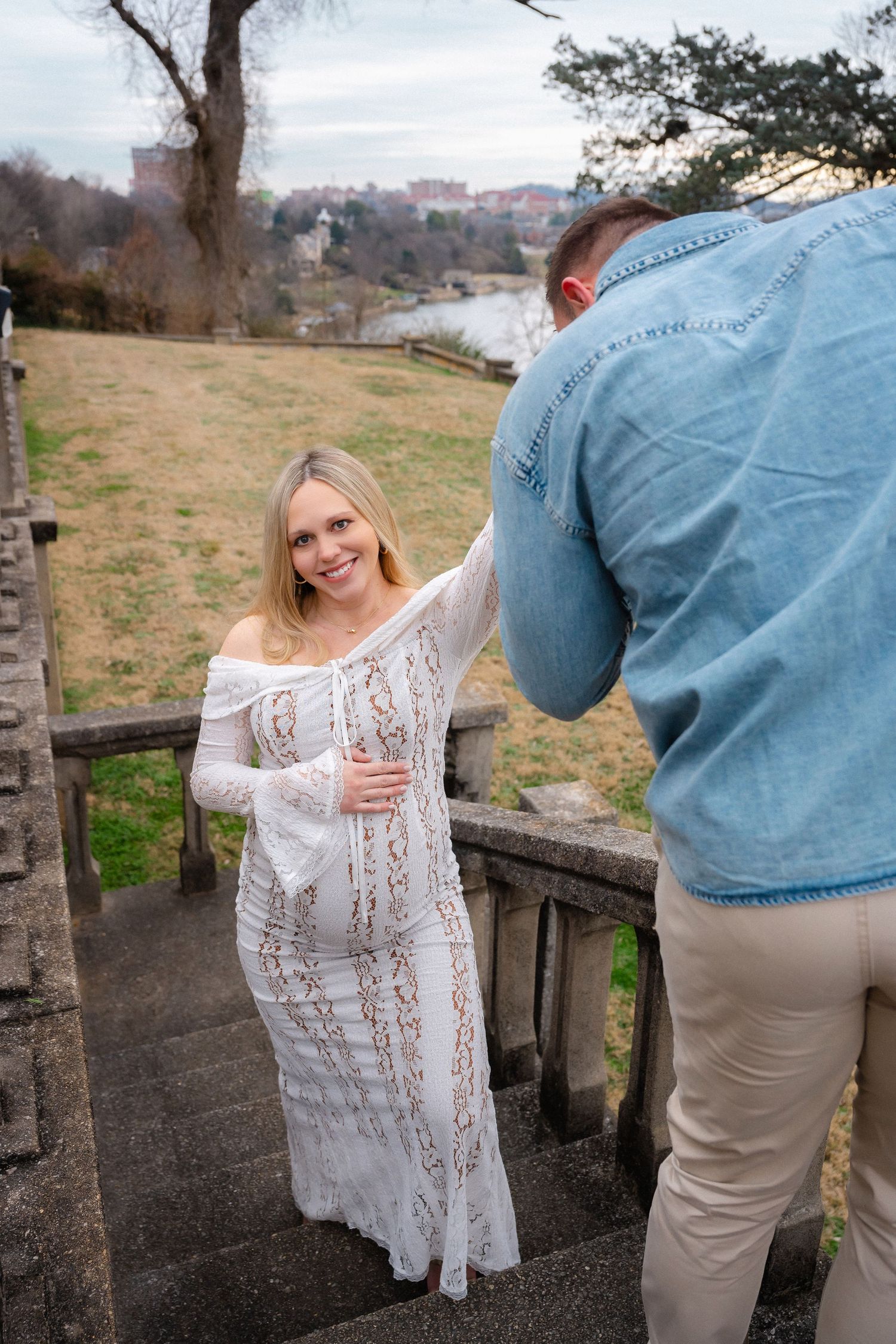 Couple shares intimate moment during photoshoot near stone architecture.