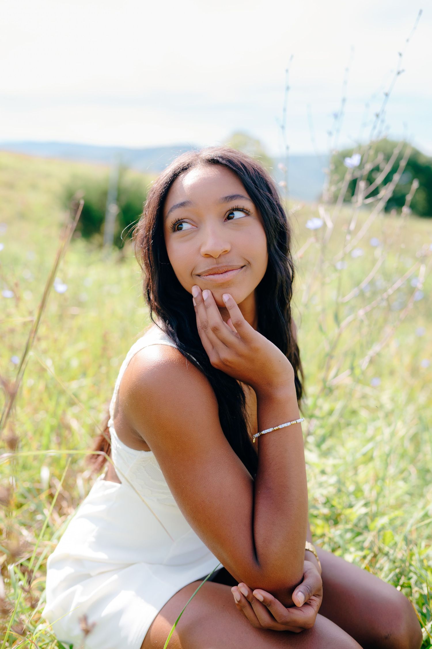 Dreamy outdoor portrait in tall grass with soft natural lighting.