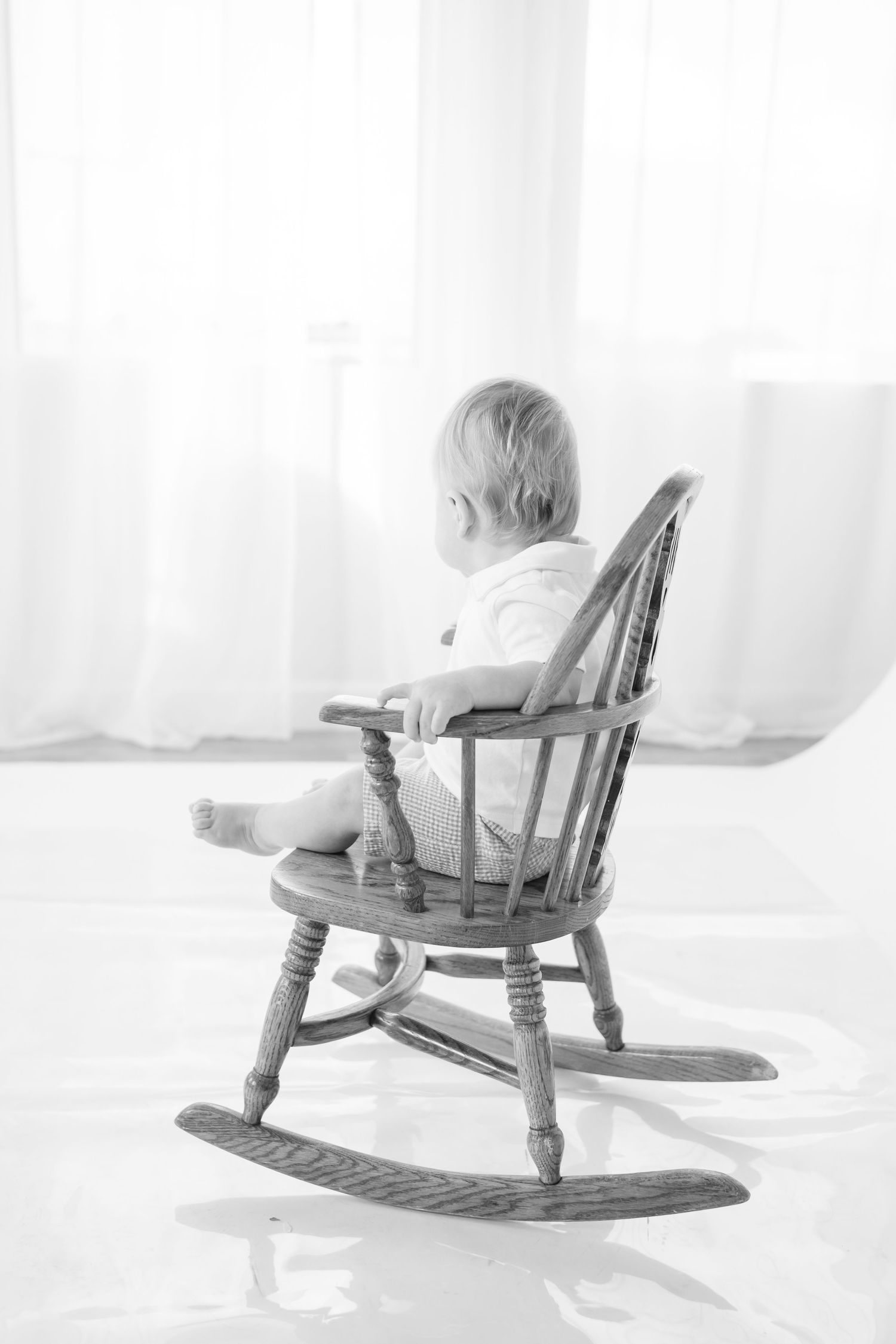 Series of black and white photos showing a baby in a wooden rocking chair.