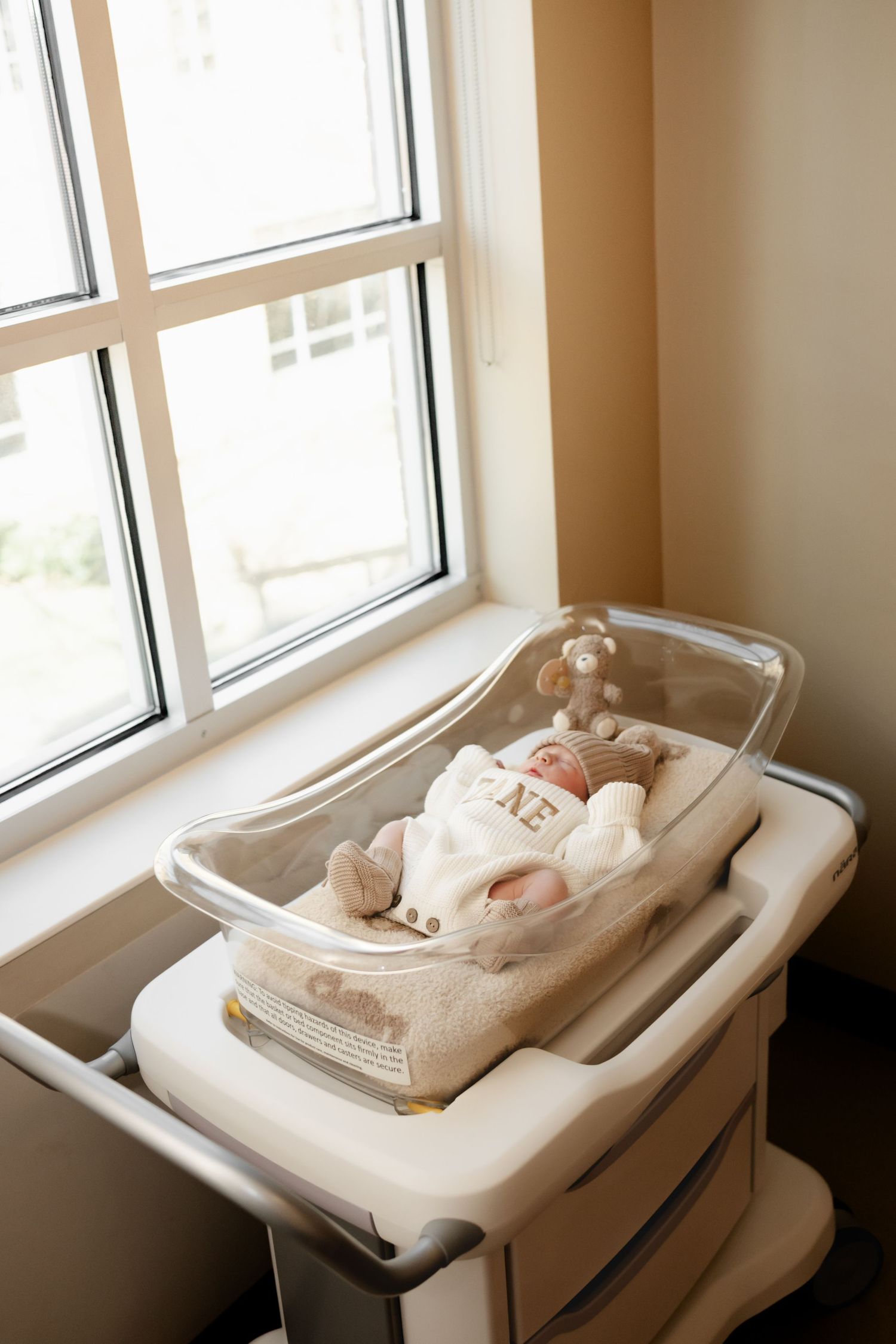 Multiple views of an empty white baby changing table installed near a bright window.