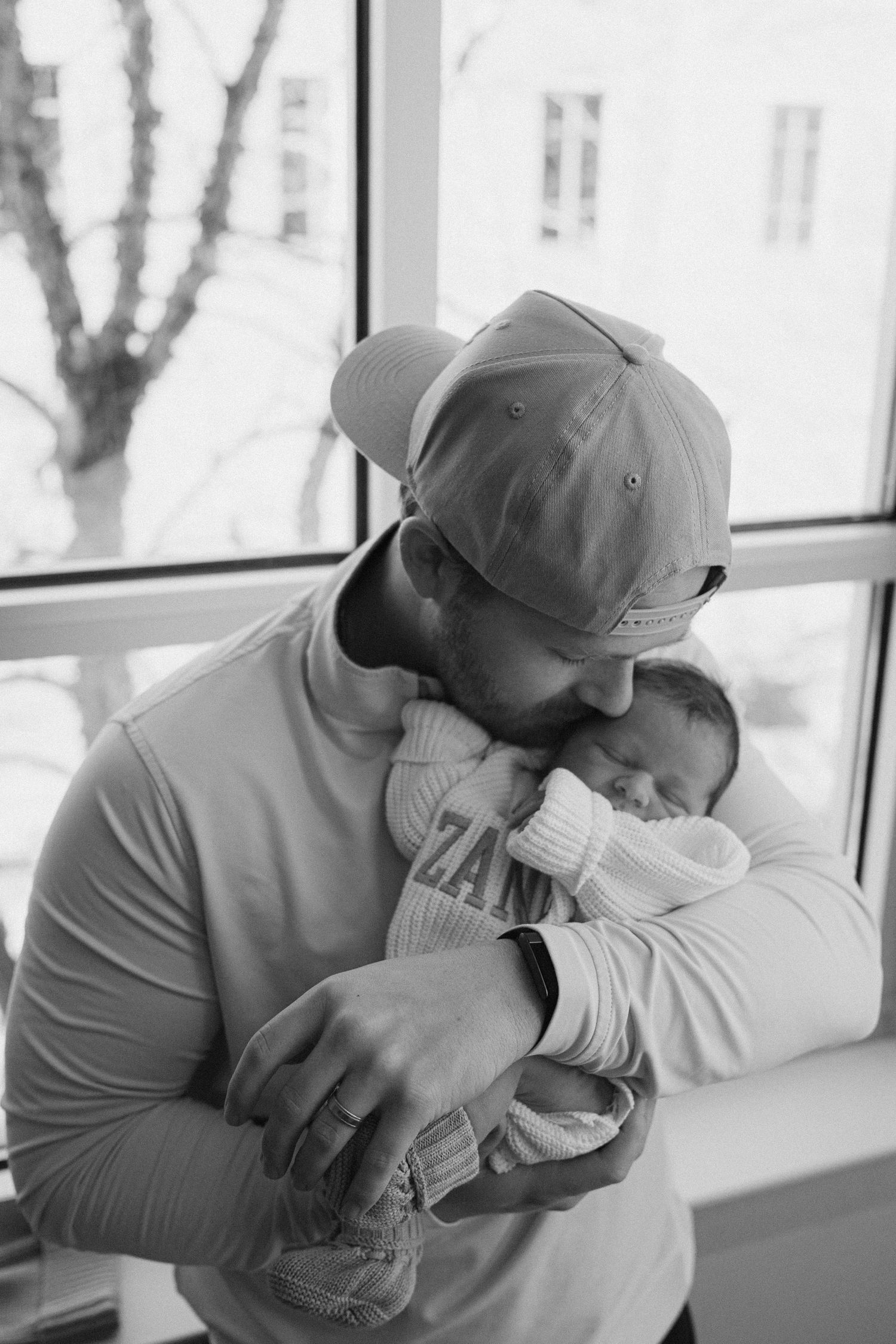 Series of black and white photos showing tender moments between parent and newborn.