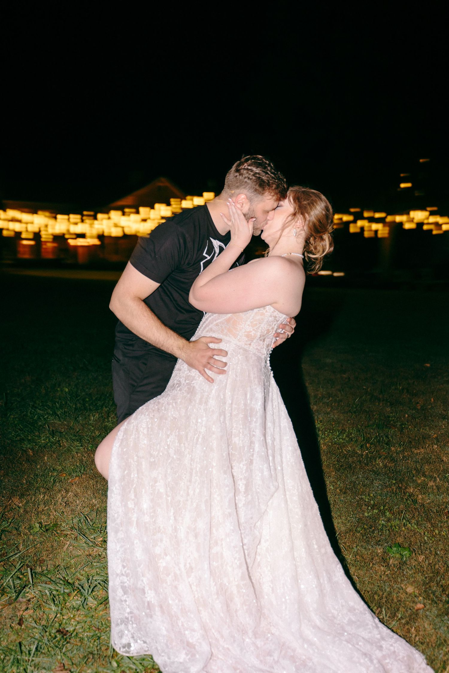 Evening wedding photos on grass showing intimate moments in a white lace dress.