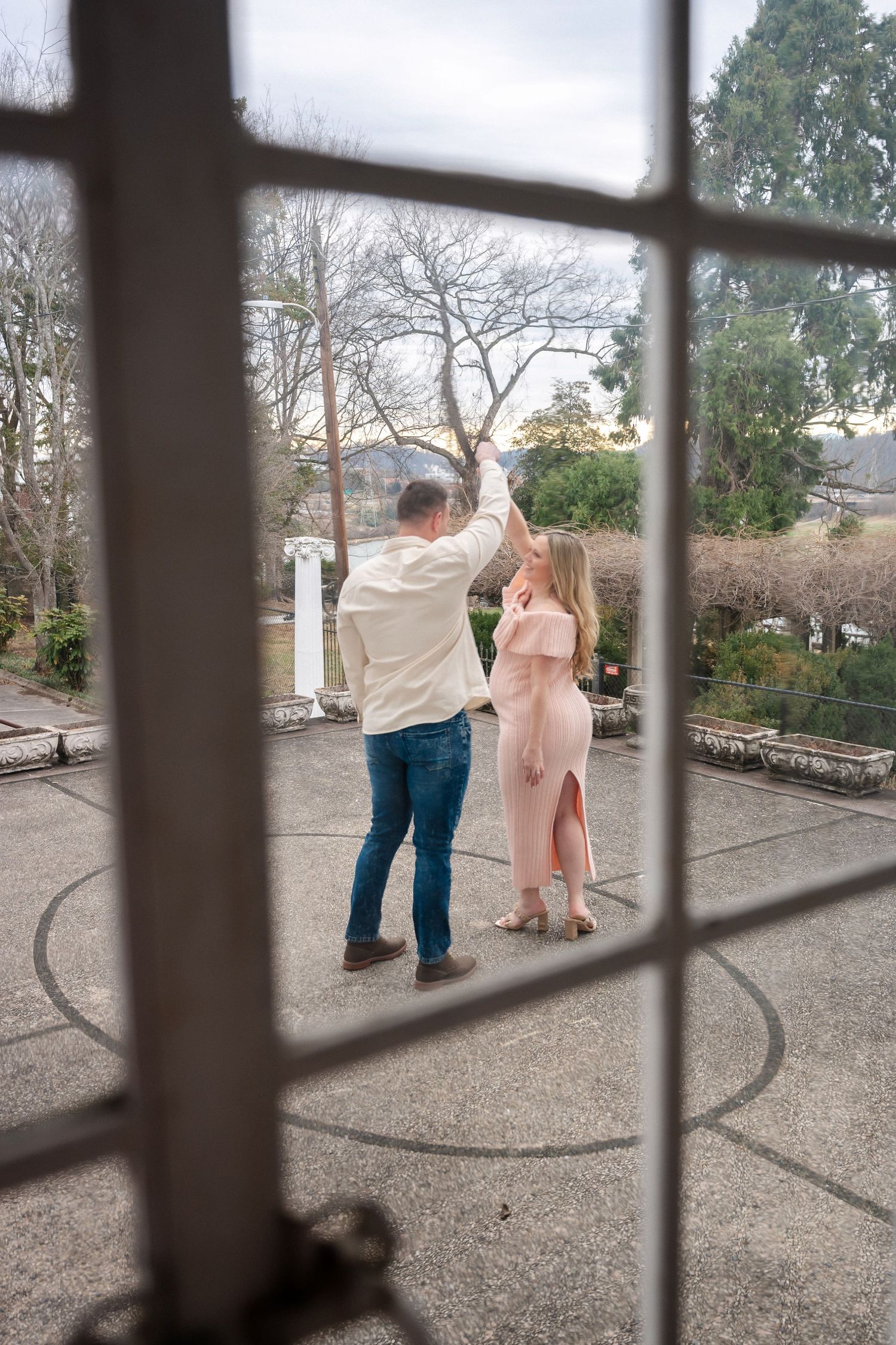 A couple seen through window panes on a concrete patio.