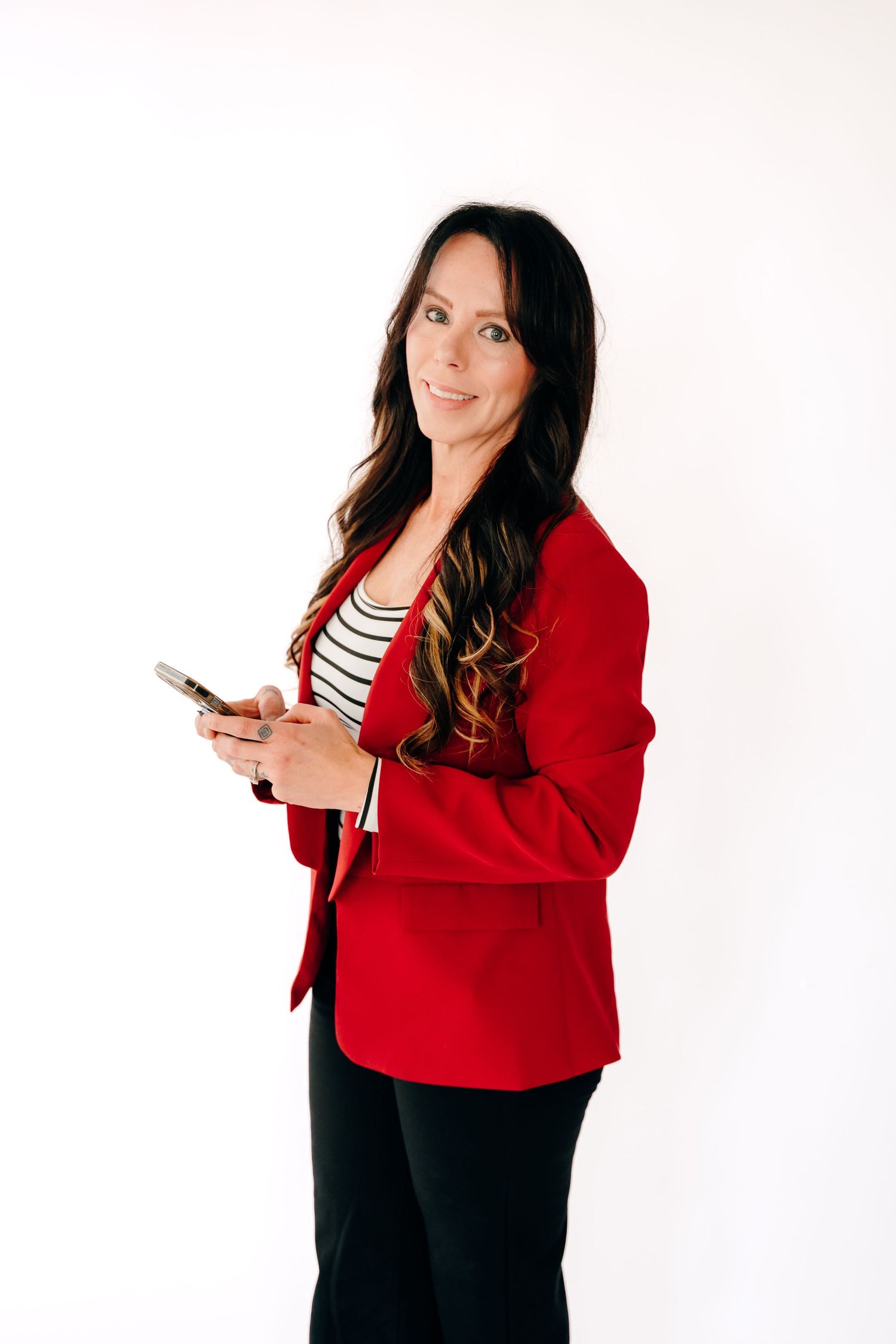 Woman in red blazer and striped shirt poses with phone against white background in three similar shots.