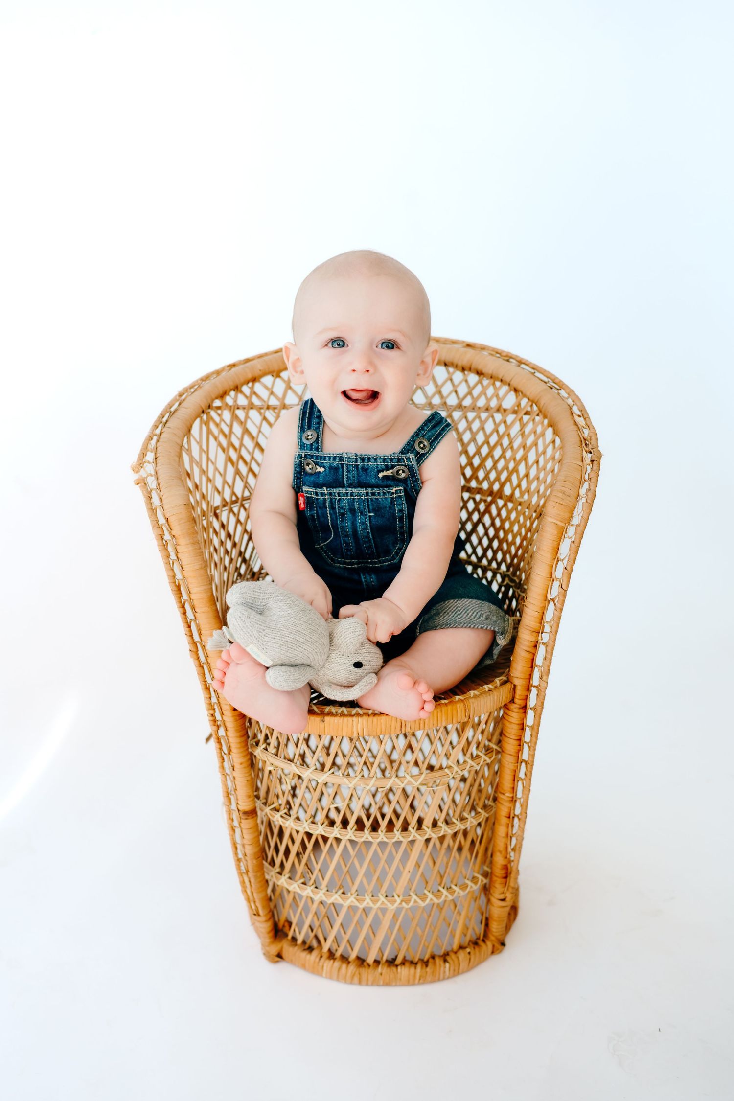 Three sequential photos of a baby sitting in a vintage wicker peacock chair against a white background.