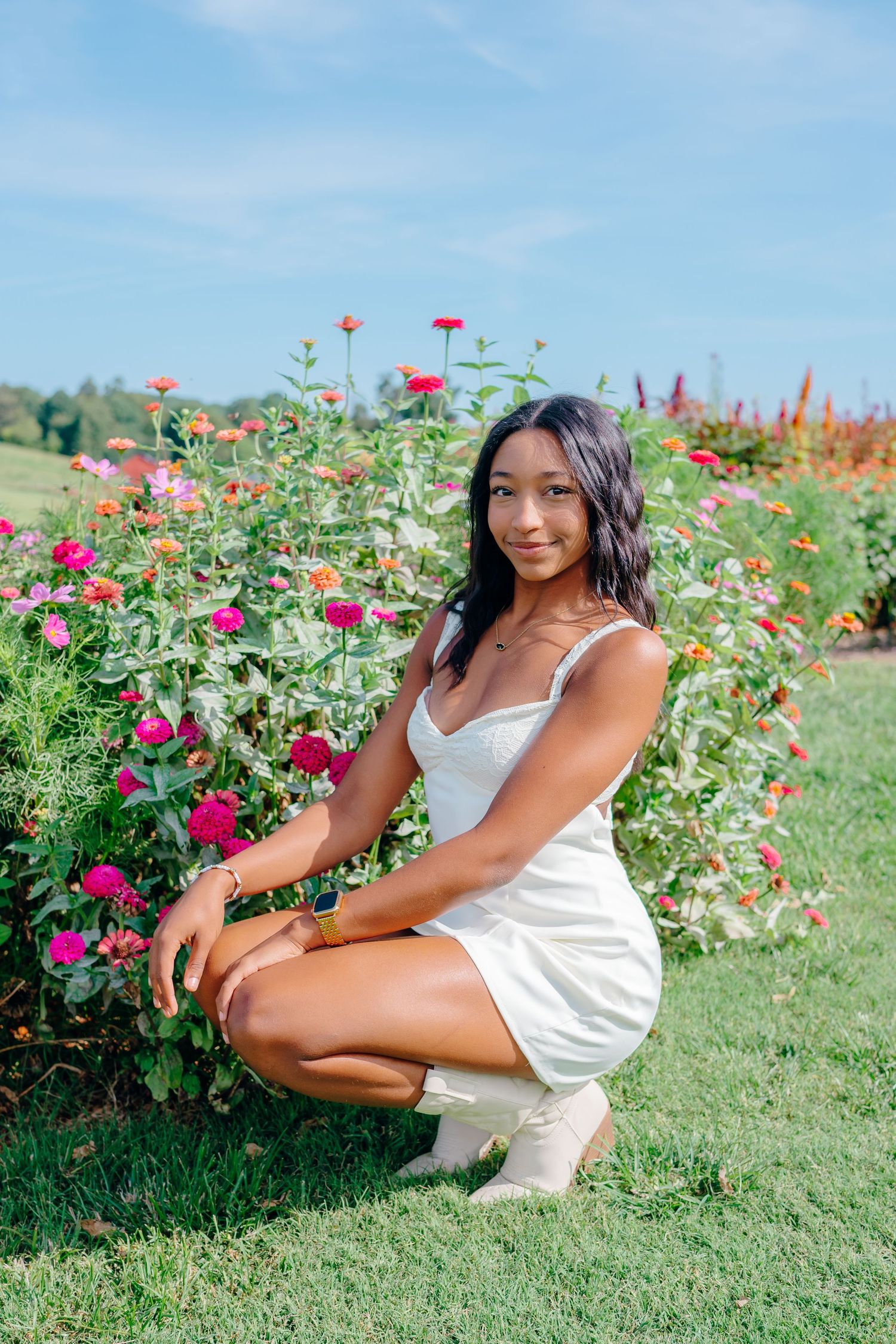 Summer portrait session among pink roses in a lush garden setting.