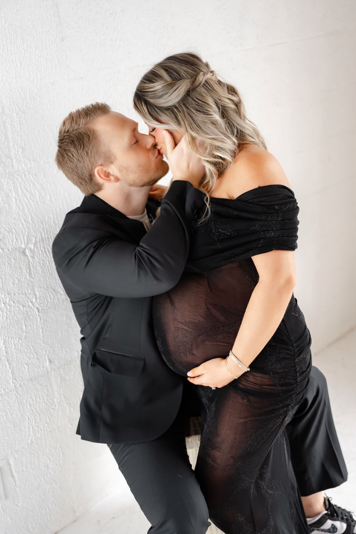 Romantic maternity portrait with couple in black formal attire.