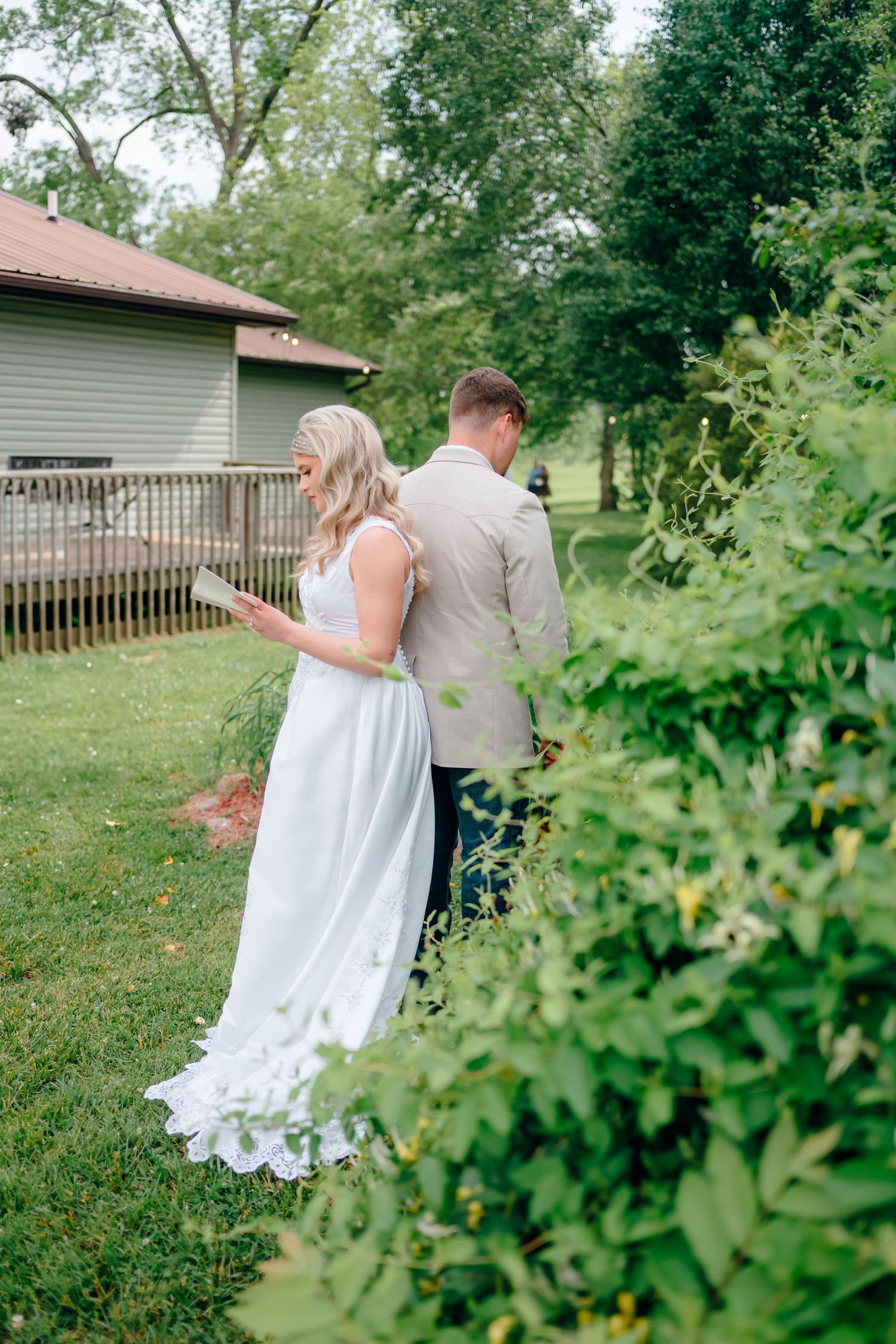 A couple walking through a lush green garden setting.