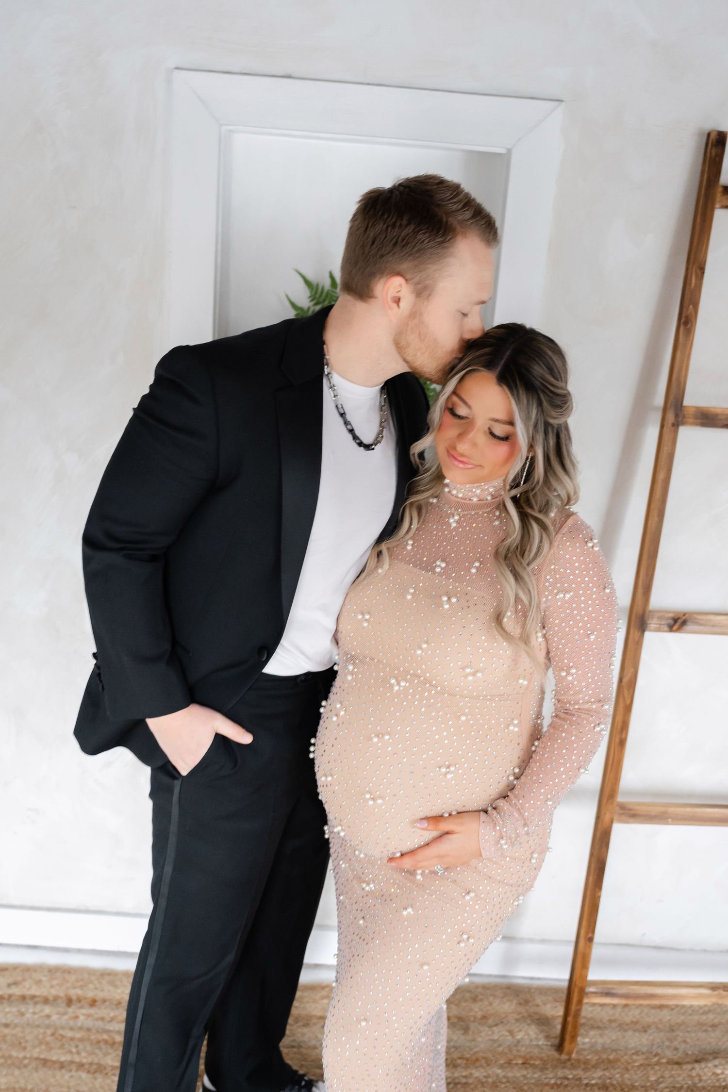 Intimate maternity photos showing loving family moments in a bright studio setting.