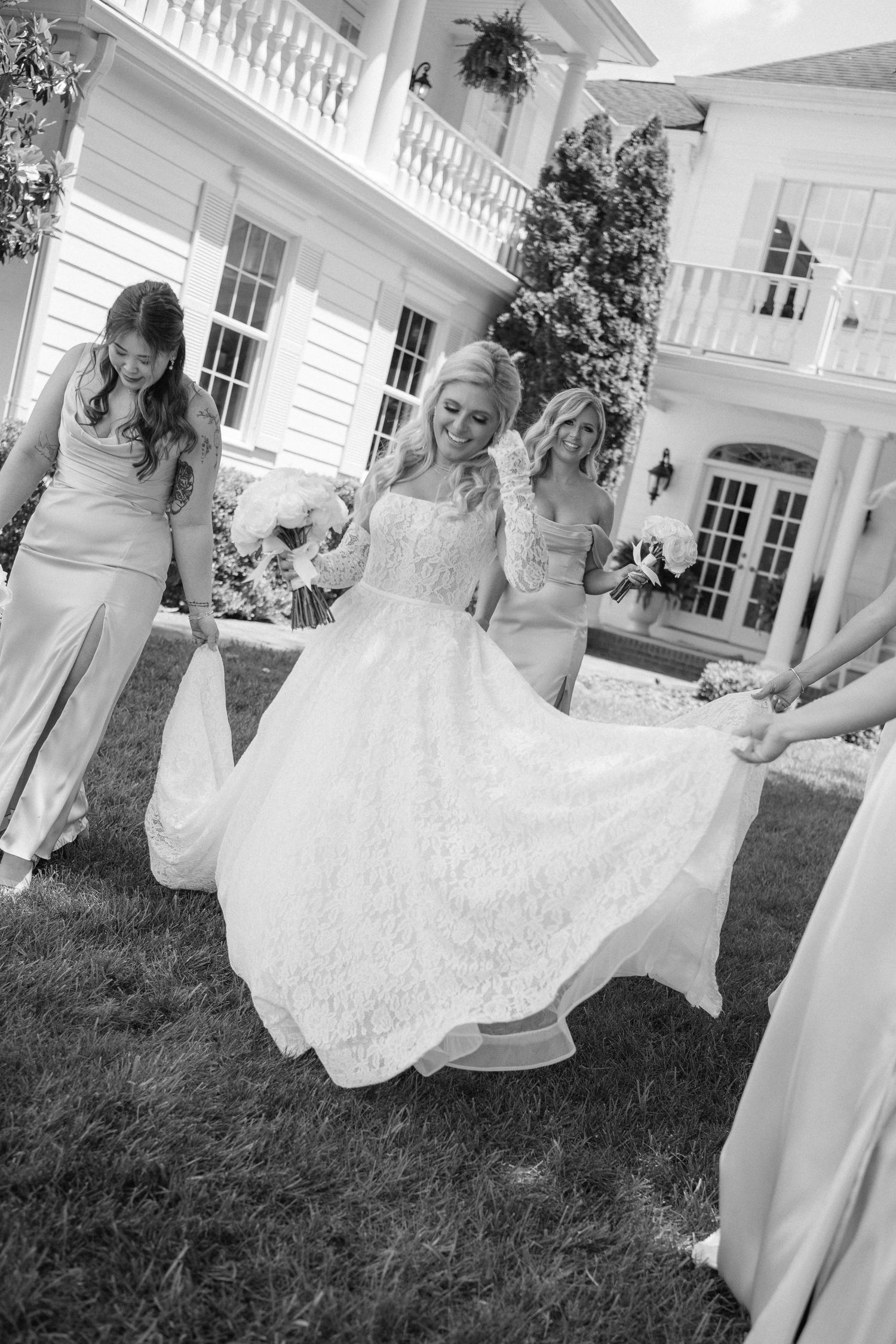 Black and white photos of bridal party arranging wedding dress on mansion grounds.