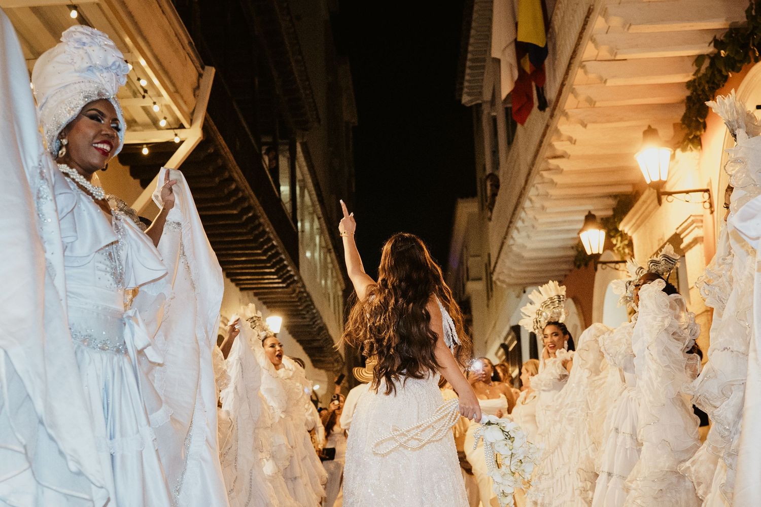 Destination bride dancing through the streets during a joyful Colombian wedding celebration.