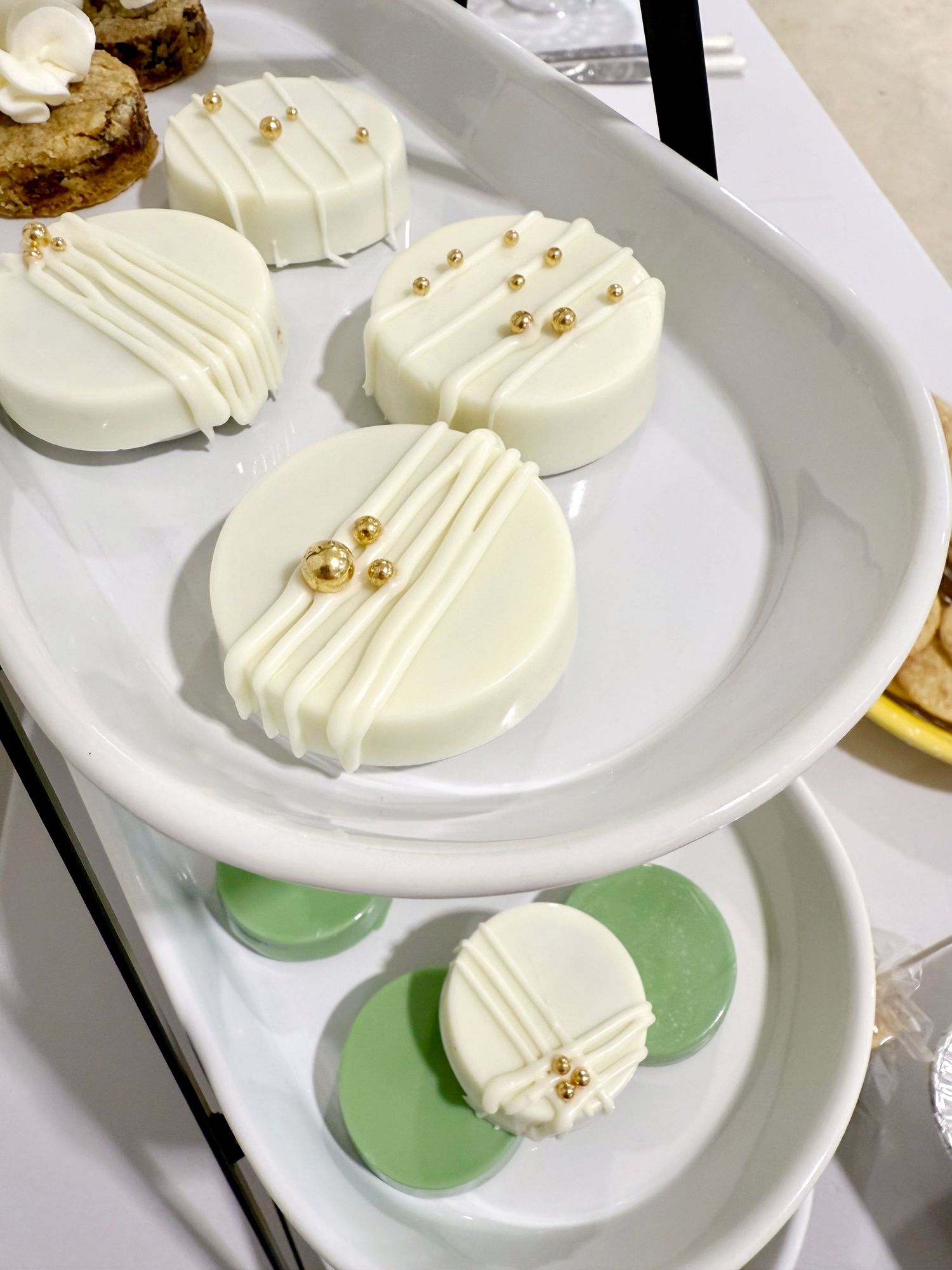 White chocolate covered dessert treats arranged on green plates.