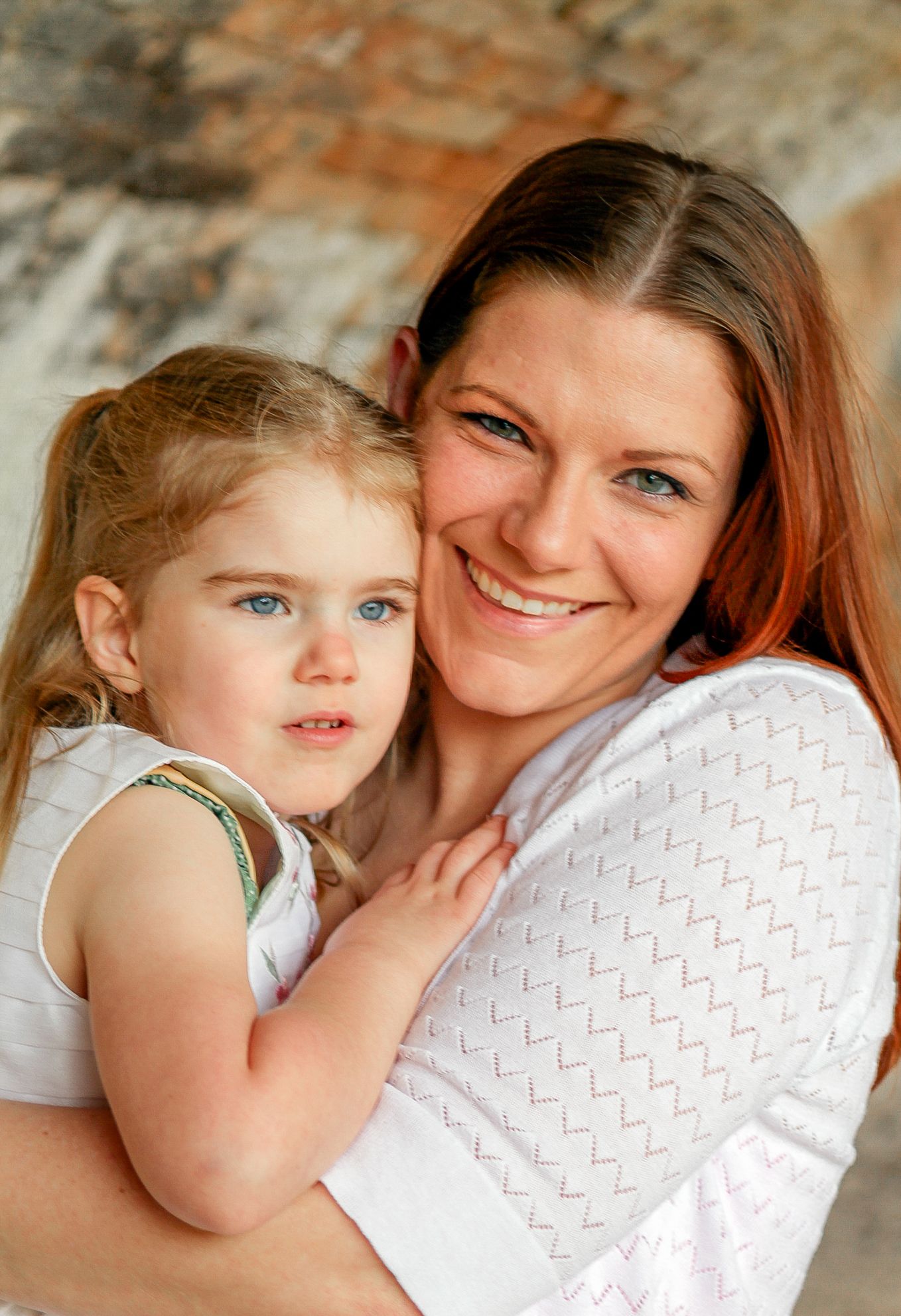 A heartwarming sequence of candid moments between parent and child against a textured stone wall background.