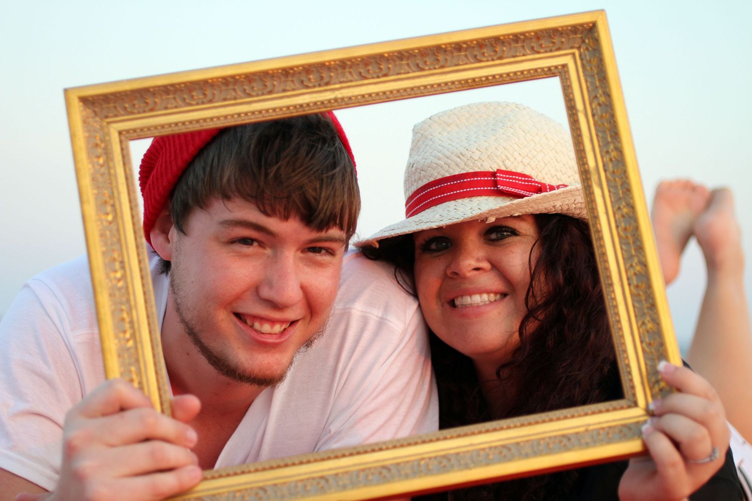 Decorative gold picture frames lined up in a row showing multiple people posing playfully through the frames.