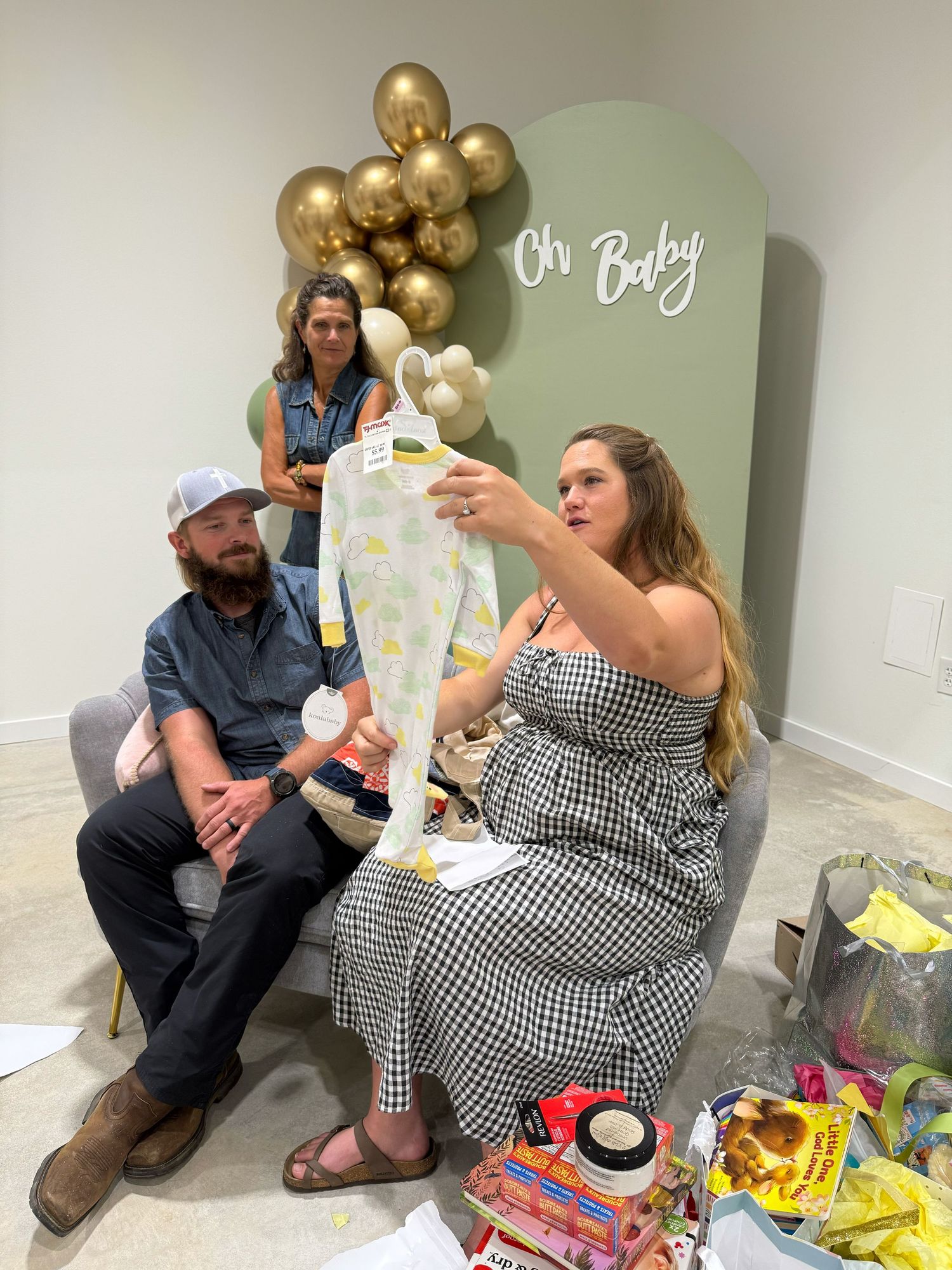 Decorated room setup with balloon garland and present opening area for a baby shower celebration.