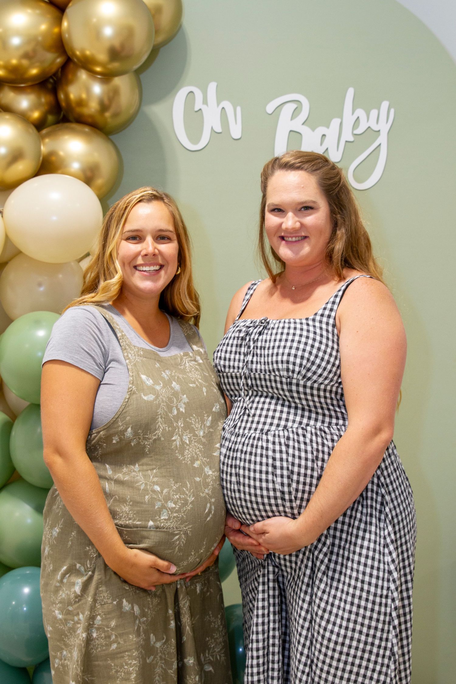 Festive setup with gold balloon decorations against a mint green wall for a celebration.