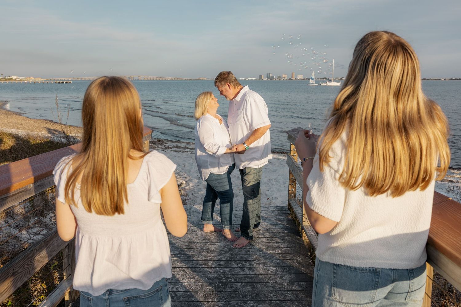 A family gathering at sunset near the ocean with the city skyline visible in the background.