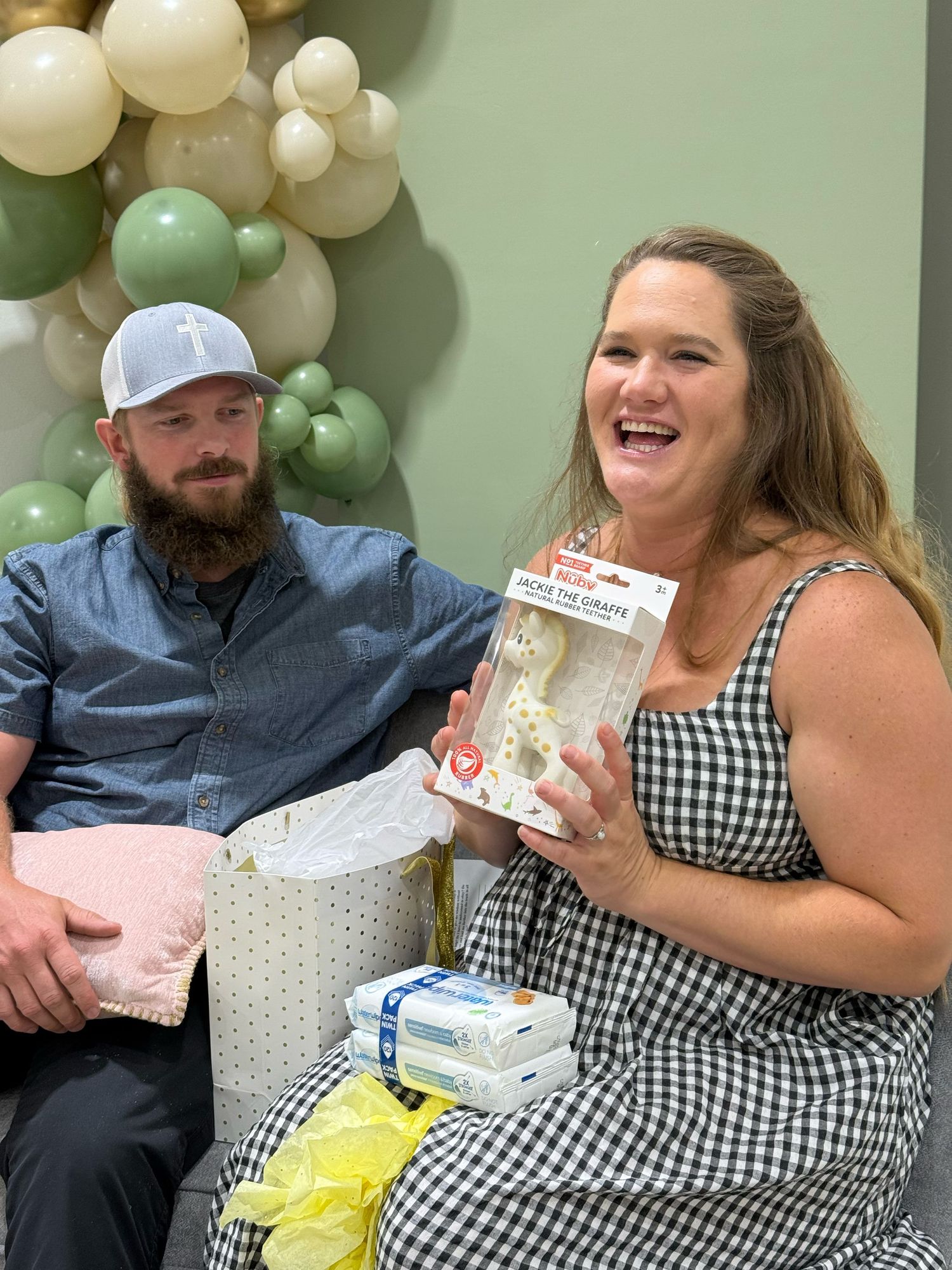Gift opening celebration at a baby shower with balloon decorations and presents.