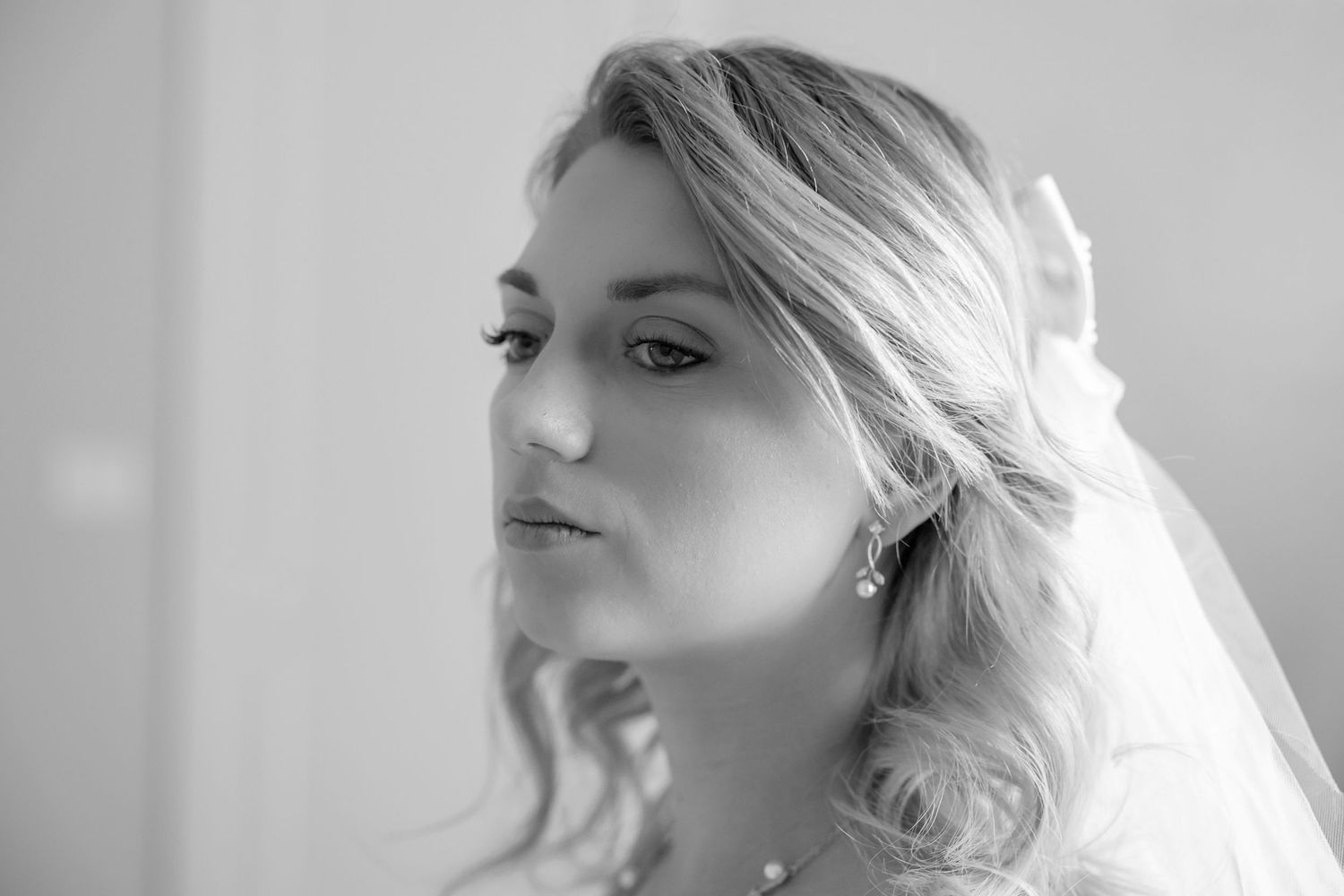 Black and white photo series showing close-up profile views of a bride with elegant hair styling and veil.