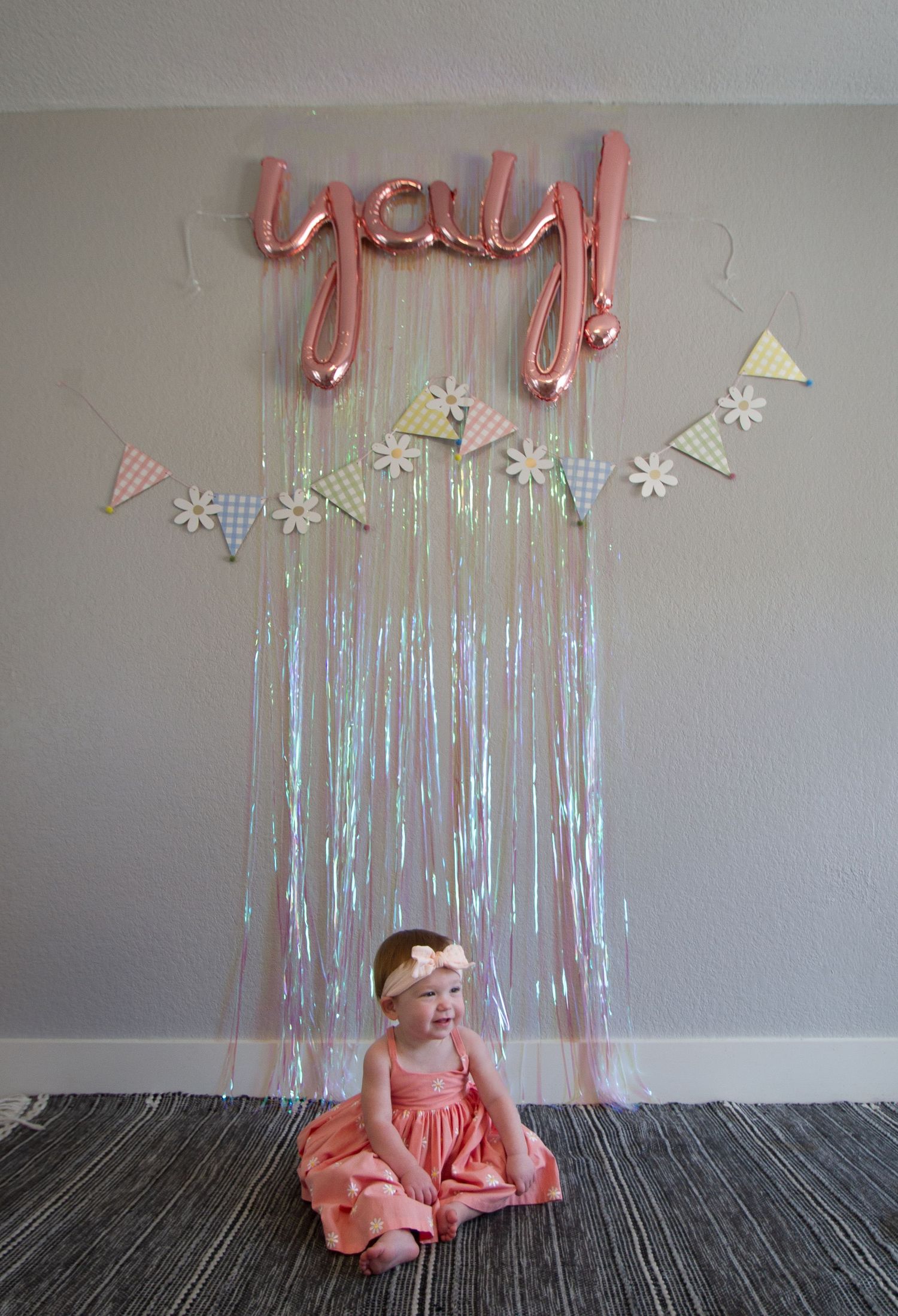 Pink balloon decorations and iridescent streamers create a dreamy backdrop for a party setting.