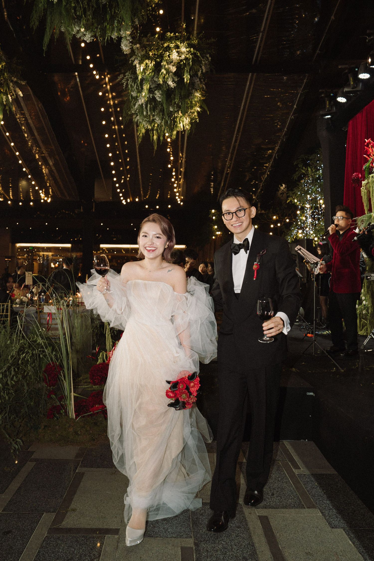 A series of four similar shots showing a bride and groom heading down a decorated walkway during an evening wedding celebration.