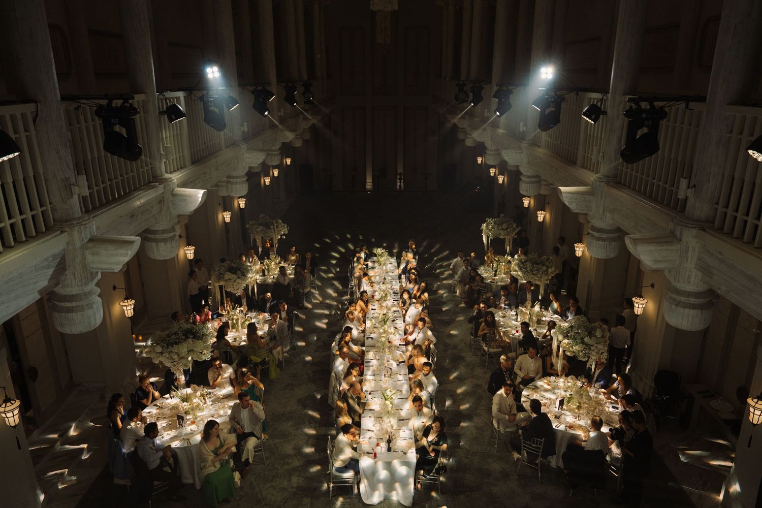 A grand ballroom set up for an elegant evening wedding reception with soft lighting and candle centerpieces.