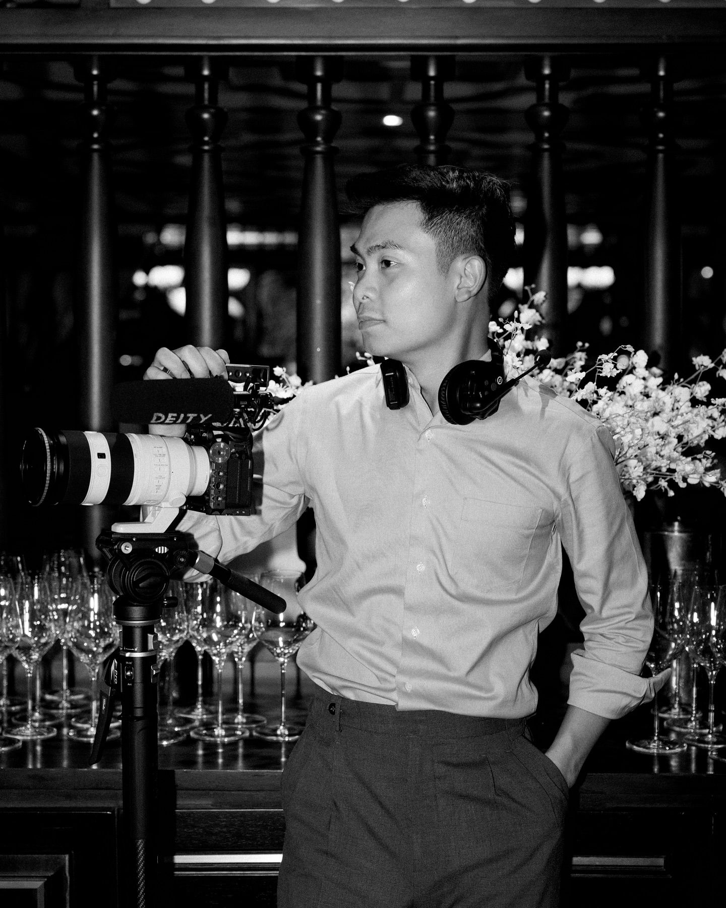 Black and white bar photography with glasses and floral arrangements.