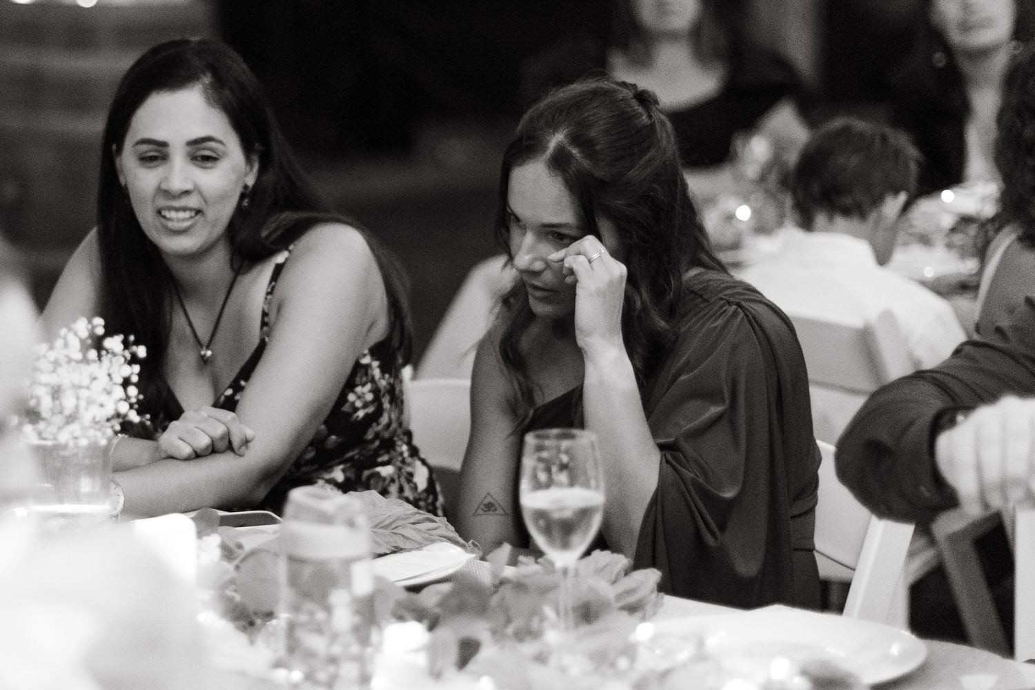 Black and white wedding reception photo showing guests seated at tables during dinner celebration.