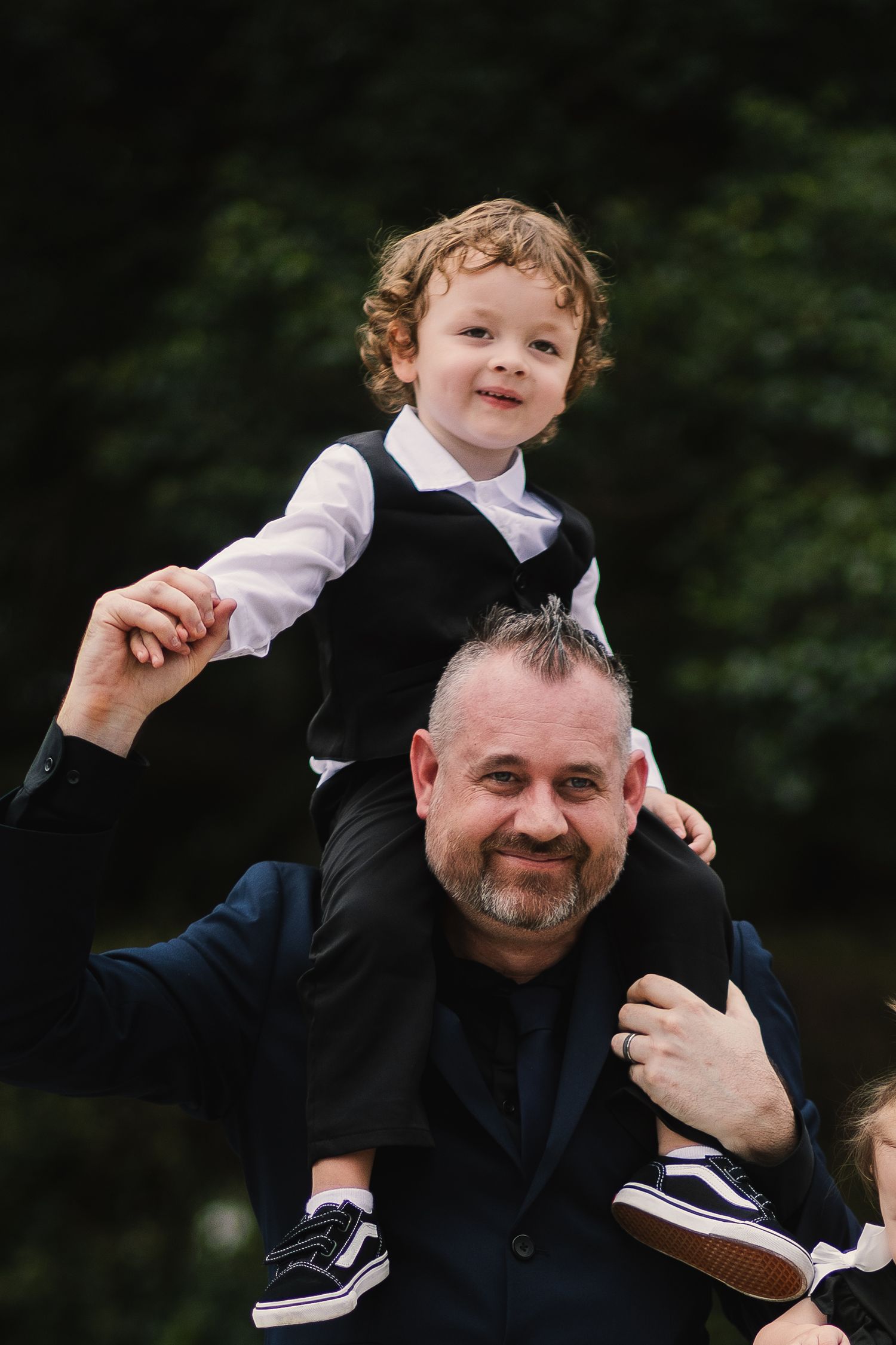 A playful moment captured as a young child rides on someone's shoulders during a fun outdoor interaction.