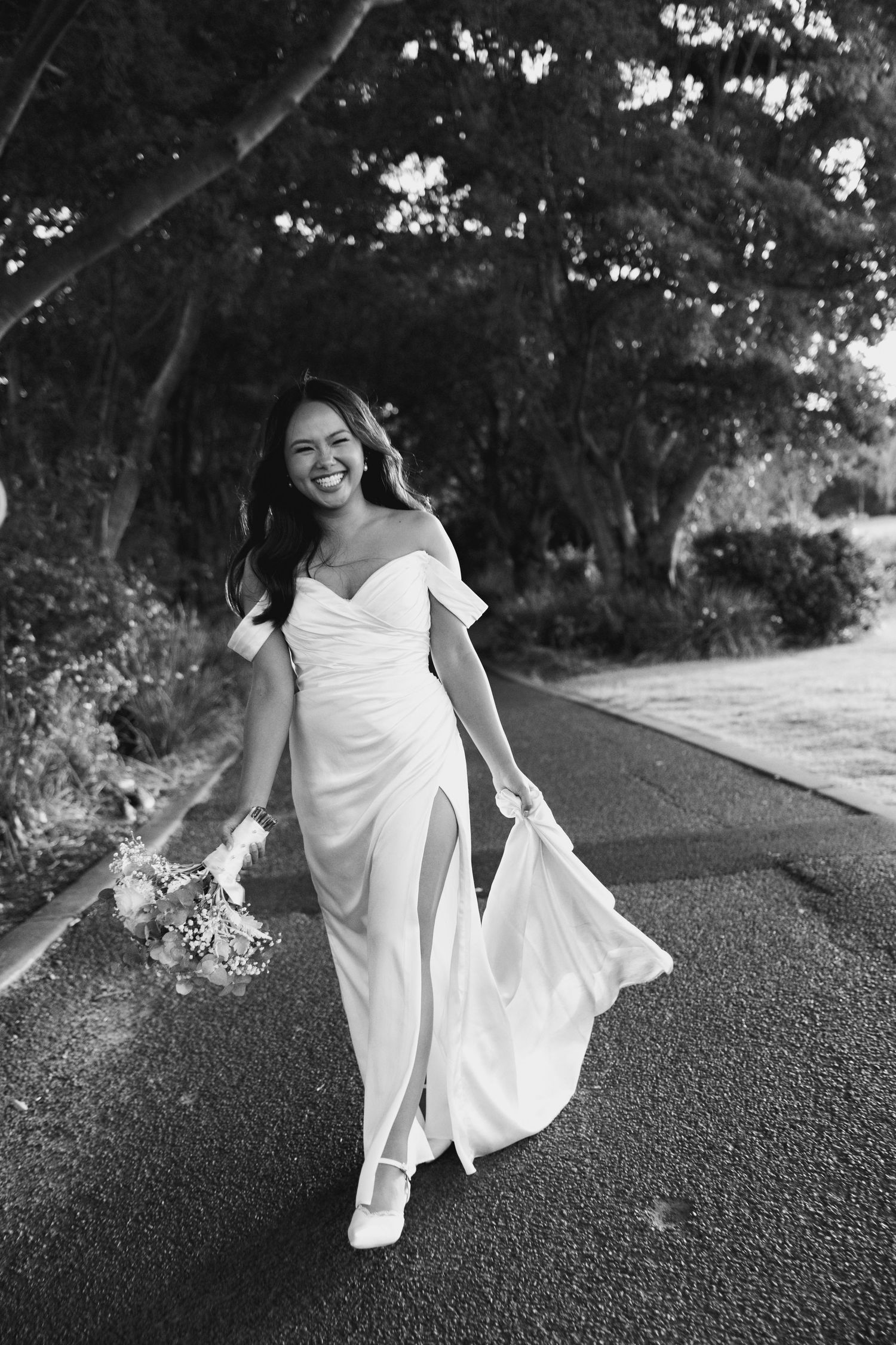 A series of black and white photos showing a person in a flowing white dress twirling and dancing on a path outdoors.