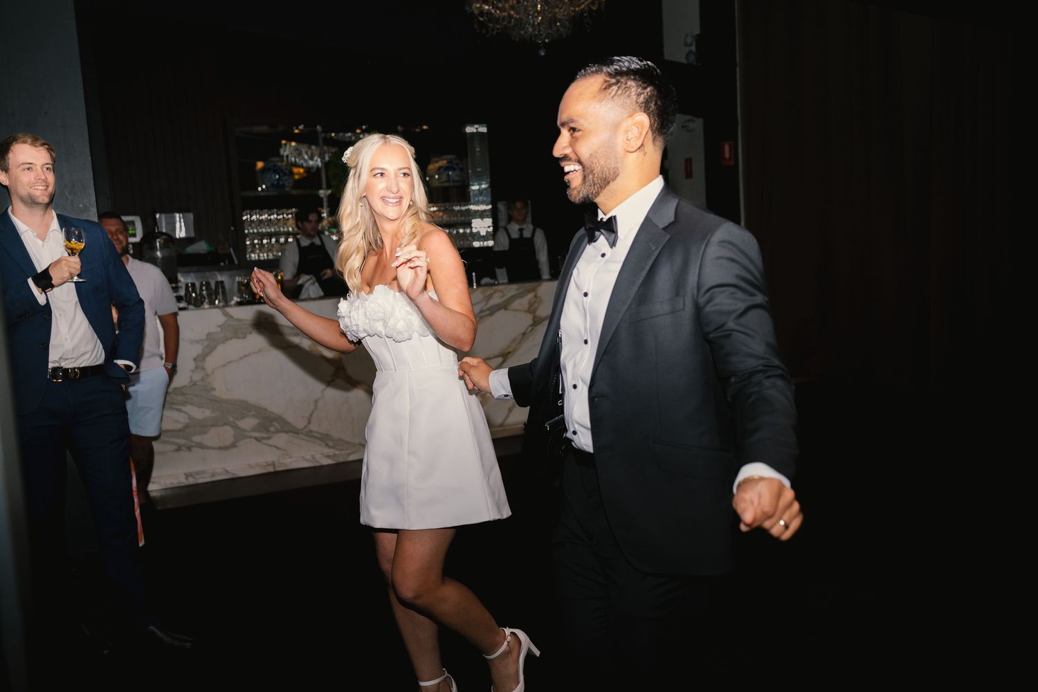 A couple dancing and laughing together at what appears to be a wedding reception or formal event.
