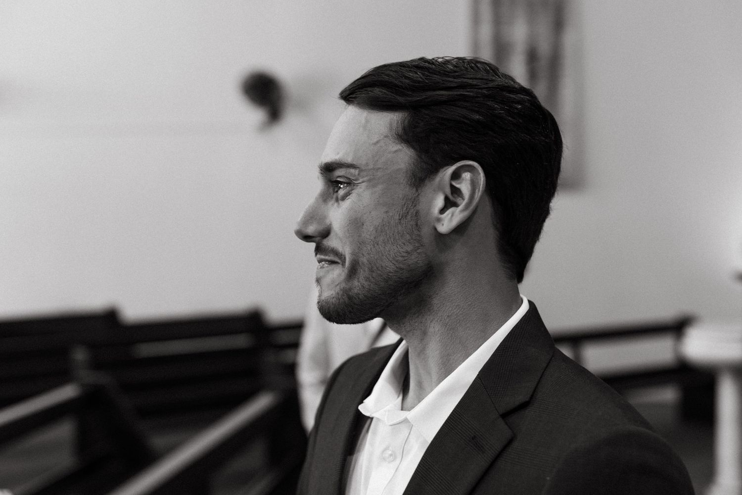 A series of black and white wedding photos showing emotional candid moments during a ceremony.