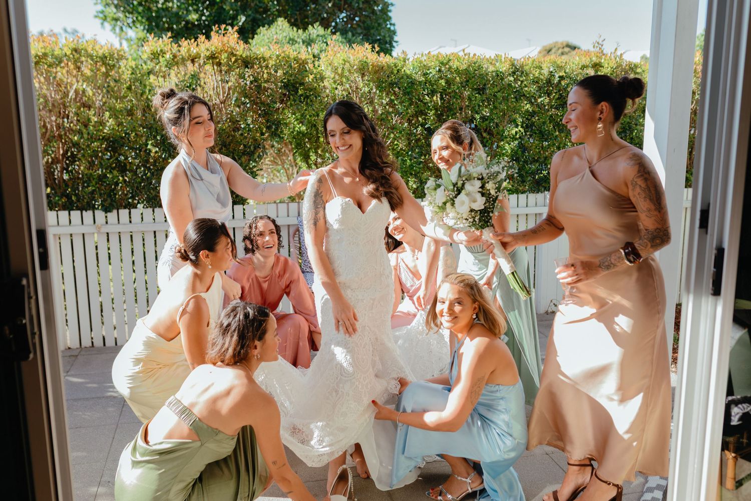 Candid shots of wedding party in pastel dresses celebrating on outdoor patio.