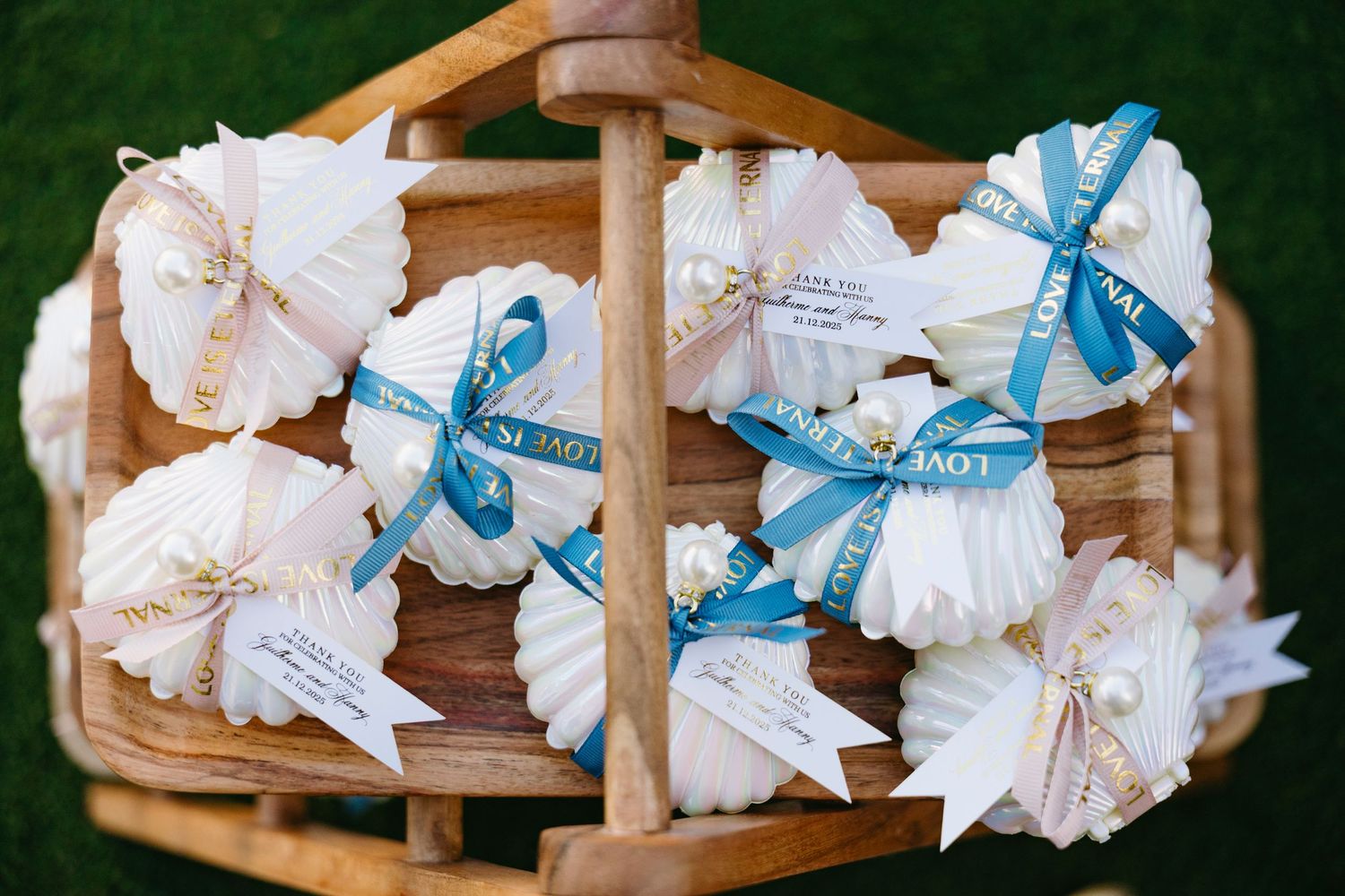 Rustic wooden crates display white and blue wedding favors with ribbons arranged in a decorative pattern.