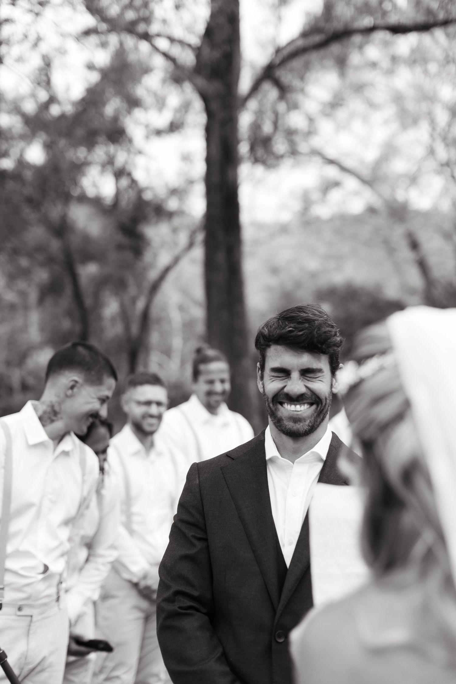 Black and white wedding photo showing guests and wedding party gathered outdoors.