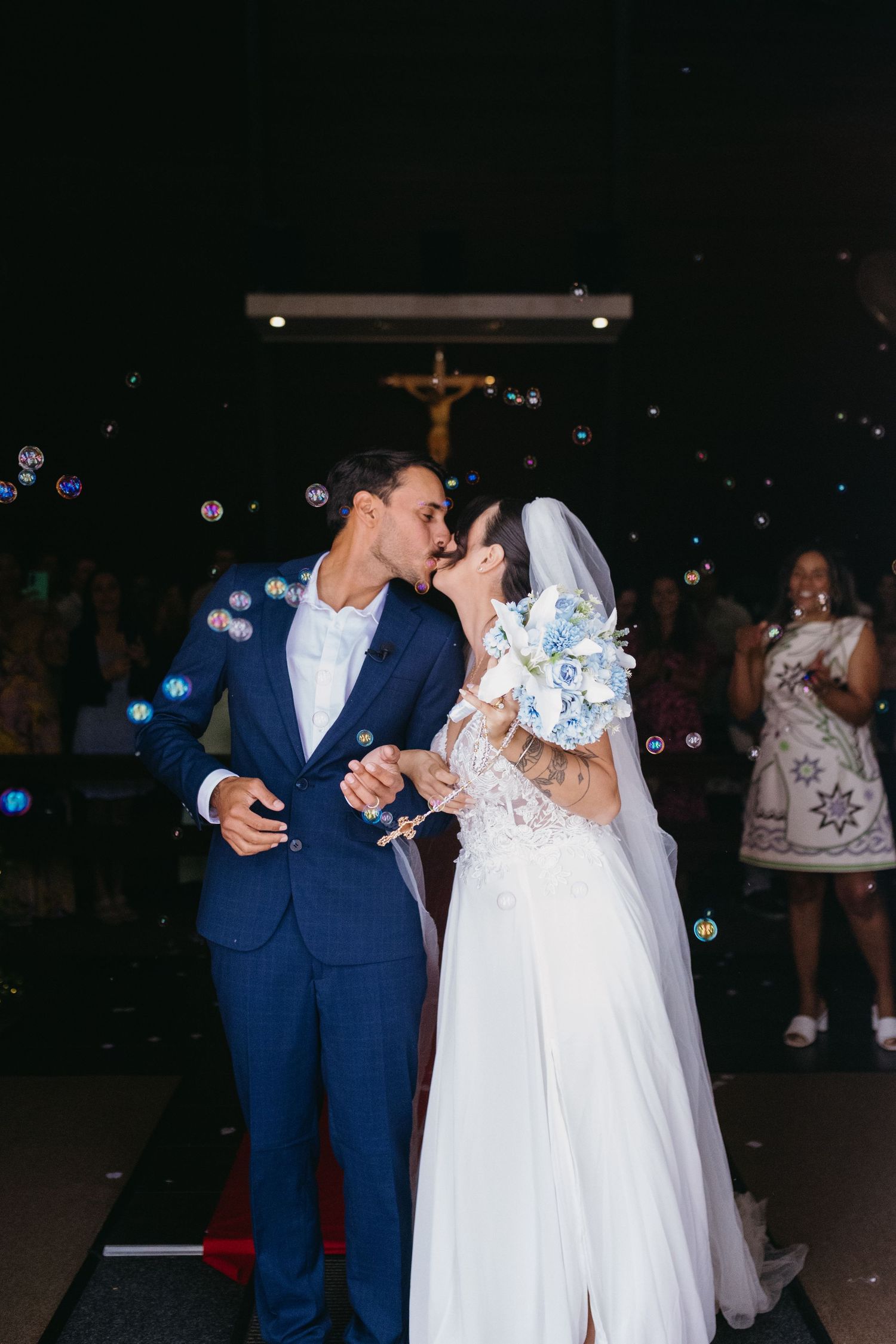 A couple dances under twinkling lights at their evening wedding reception.