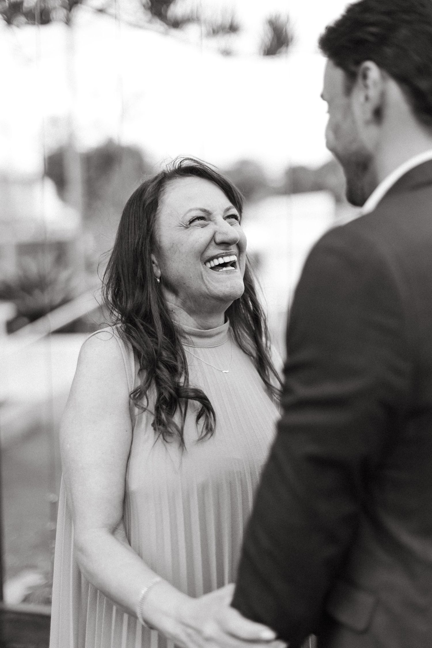 A series of candid moments showing joyful laughter between wedding attendees.