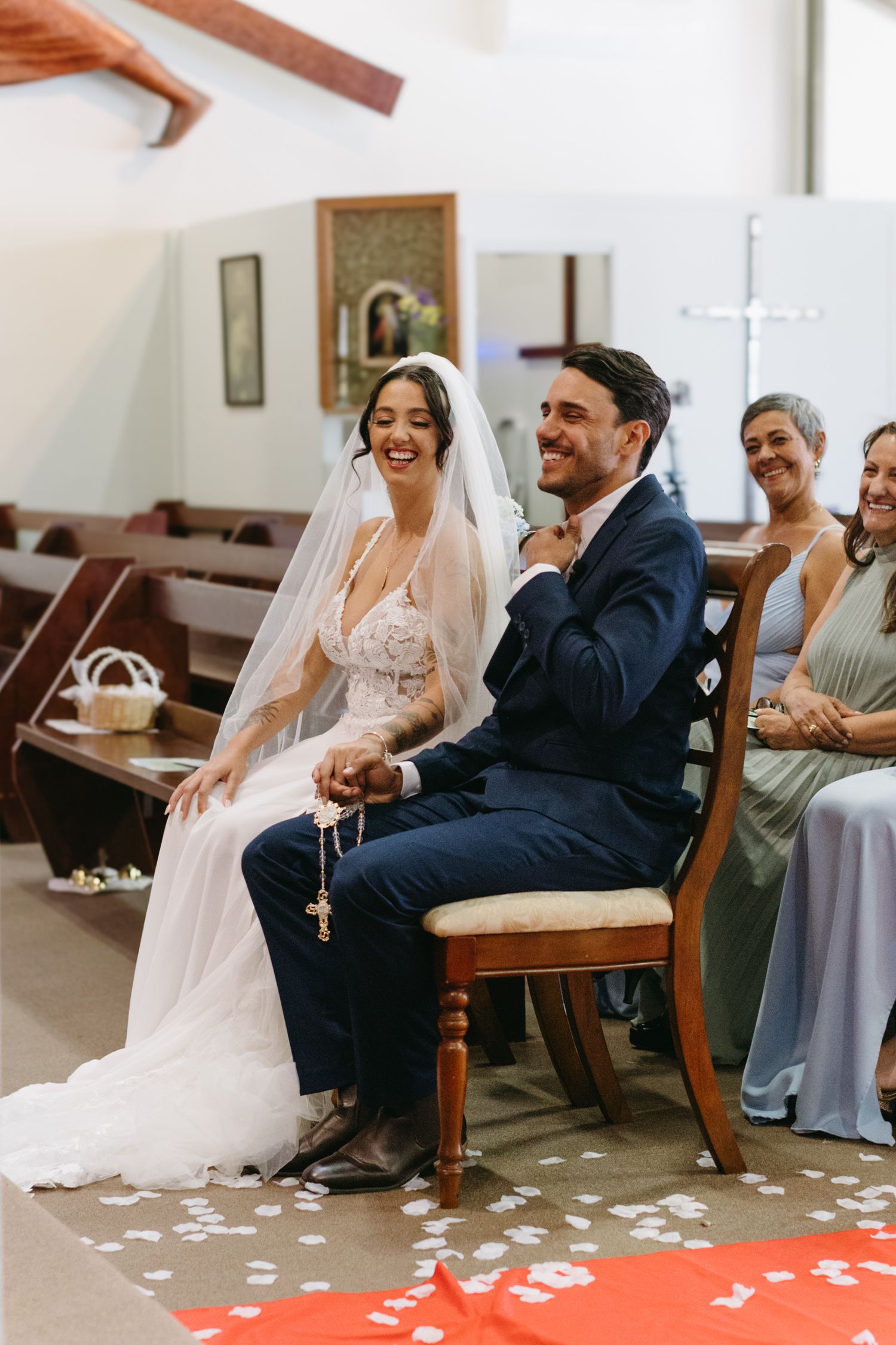 A couple shares a lighthearted moment during their wedding ceremony in a church setting.