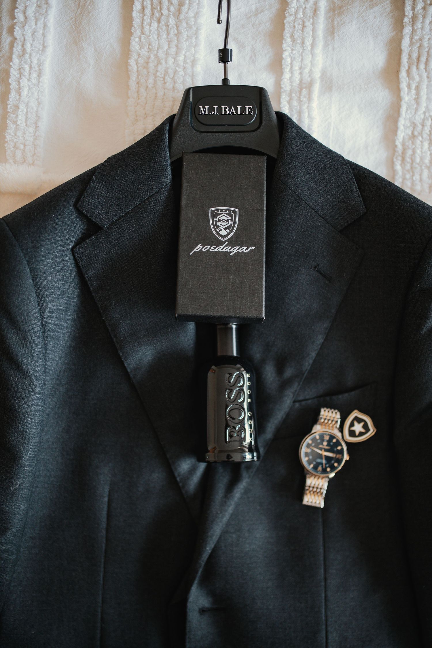 Elegant black suit jacket with luxury watch and accessories on display.