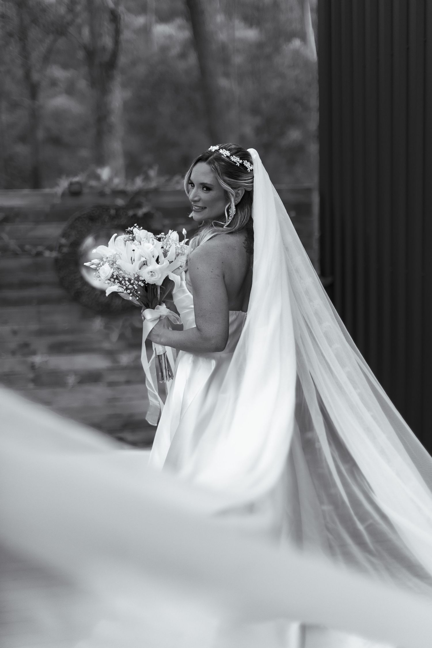 Elegant bridal portrait with flowing veil in black and white.