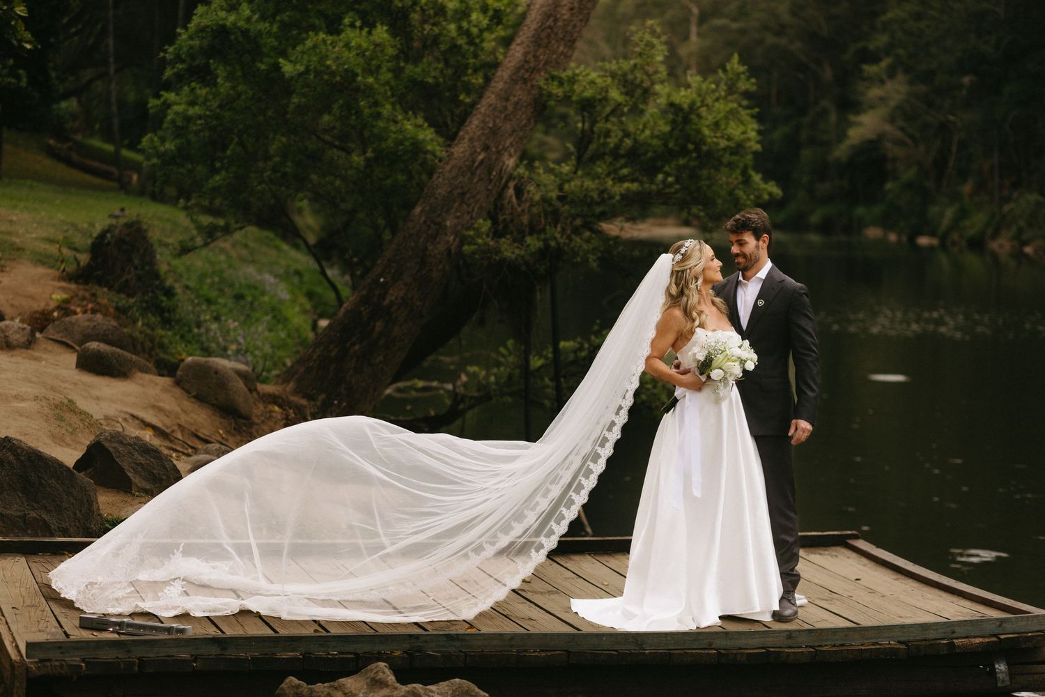 Romantic wedding photos captured on a wooden dock by a serene lake.